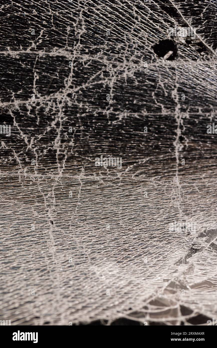 Verschmutztes Glas, das in eine große Anzahl von Teilen zerbrochen ist, ein Stück Glas mit vielen Rissen und gebrochenen Teilen Stockfoto