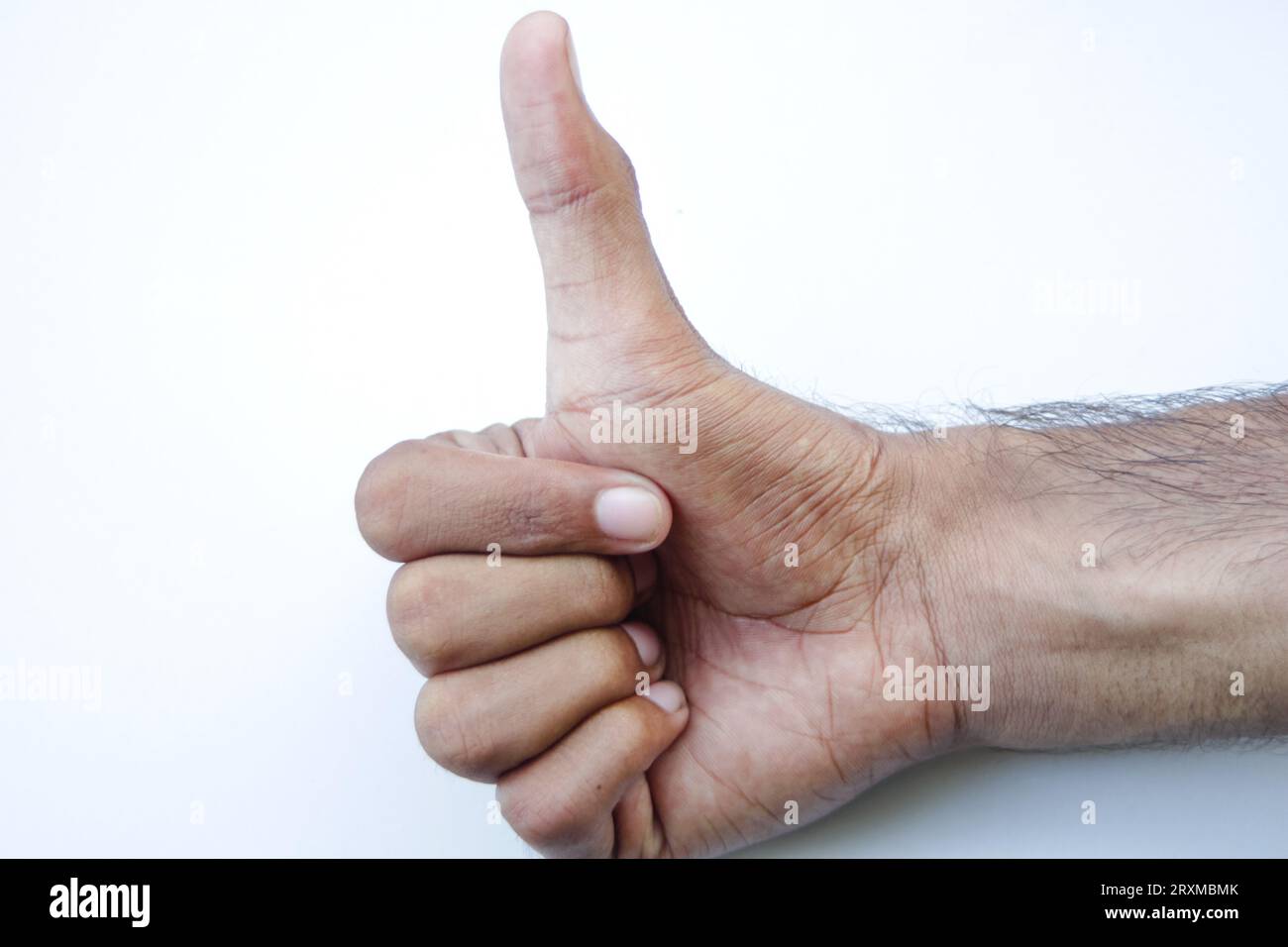 Mann Hand mit Daumen nach oben isoliert auf natürlichem grünem Hintergrund. Schild mit Daumen nach oben. Geste wird genehmigt. Isoliert über natürlichem grünem Hintergrund. Handgesten Stockfoto