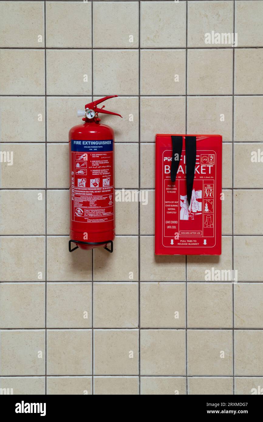 Dubai, Vereinigte Arabische Emirate - 5. Juli 2023 : Blick auf einen Feuerlöscher und eine Decke, die an einer Fliesenwand in der Küche einer Wohnwohnung montiert sind Stockfoto
