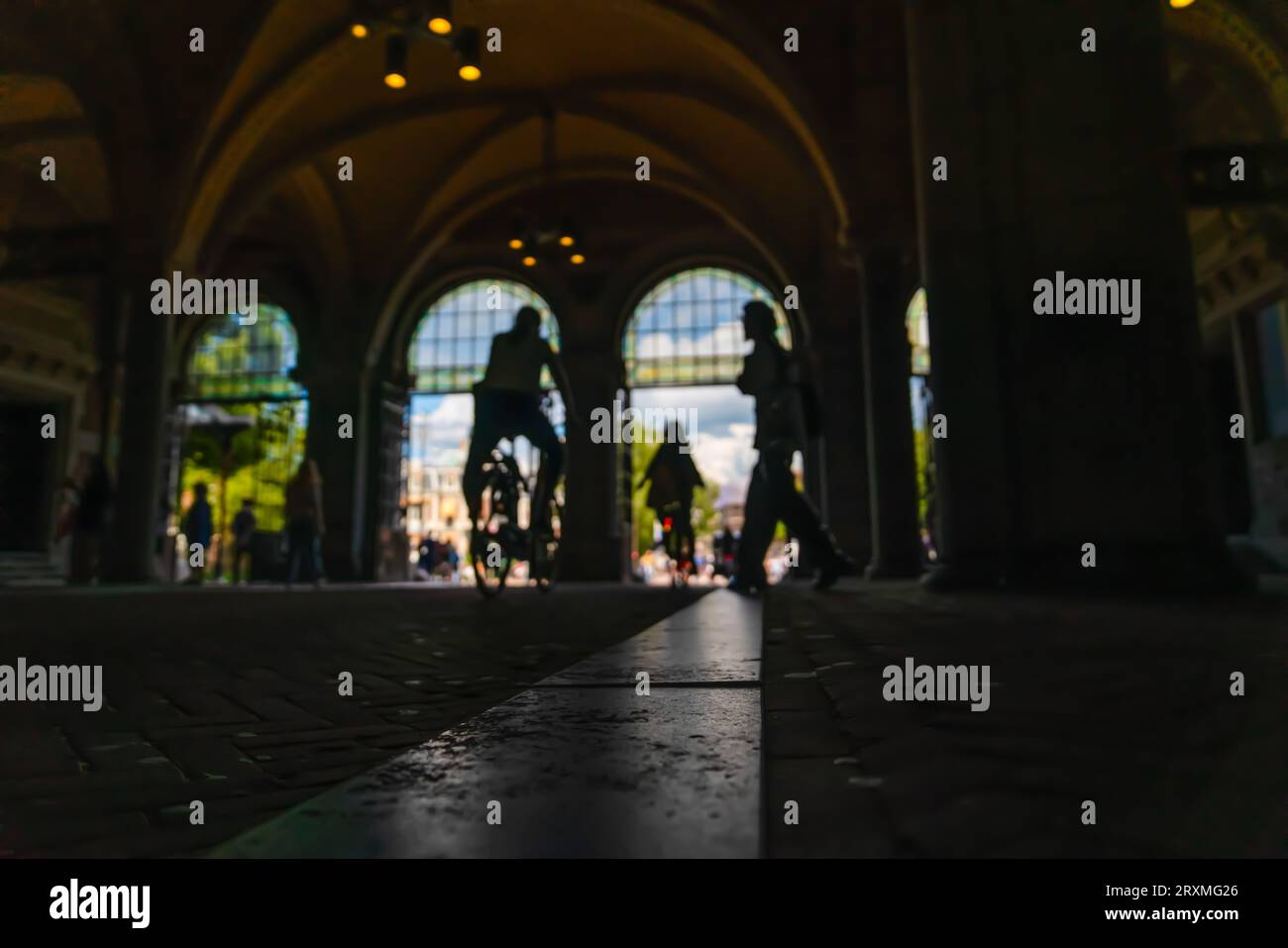Silhouette verschwommener Radfahrer, die auf dem Radweg unter dem Hauptbahnhof unterwegs sind. Stockfoto