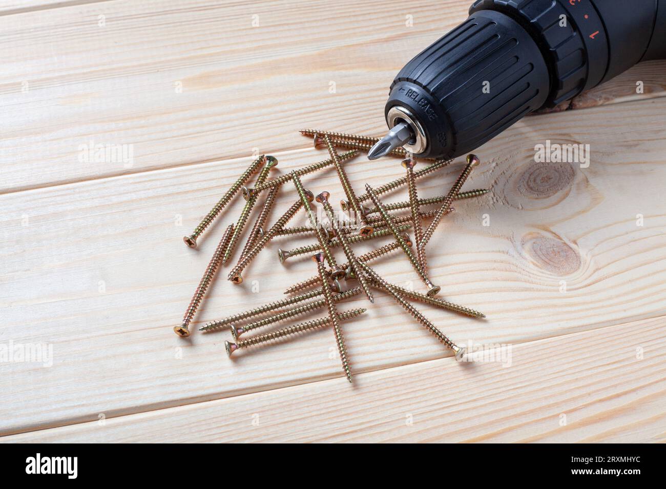 Stapel Schrauben und Schraubendreherbit auf einem Holztisch. Blechschraube für Holz Stockfoto