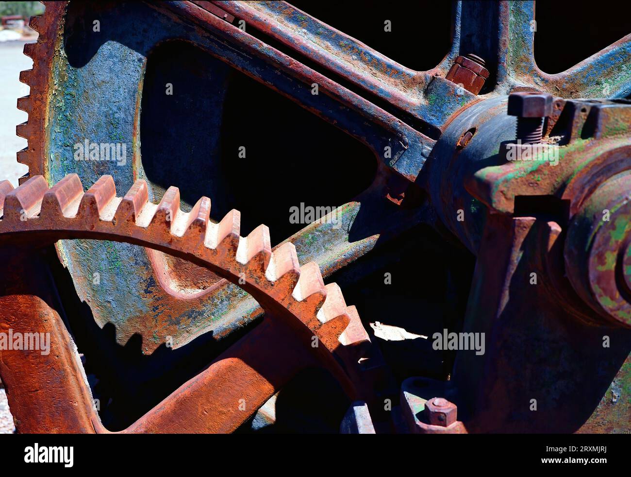 Filmbild des verlassenen Rusty Mining Iron Wheel mit Zähnen und Zahnrädern auf natürlichem Hintergrund Stockfoto