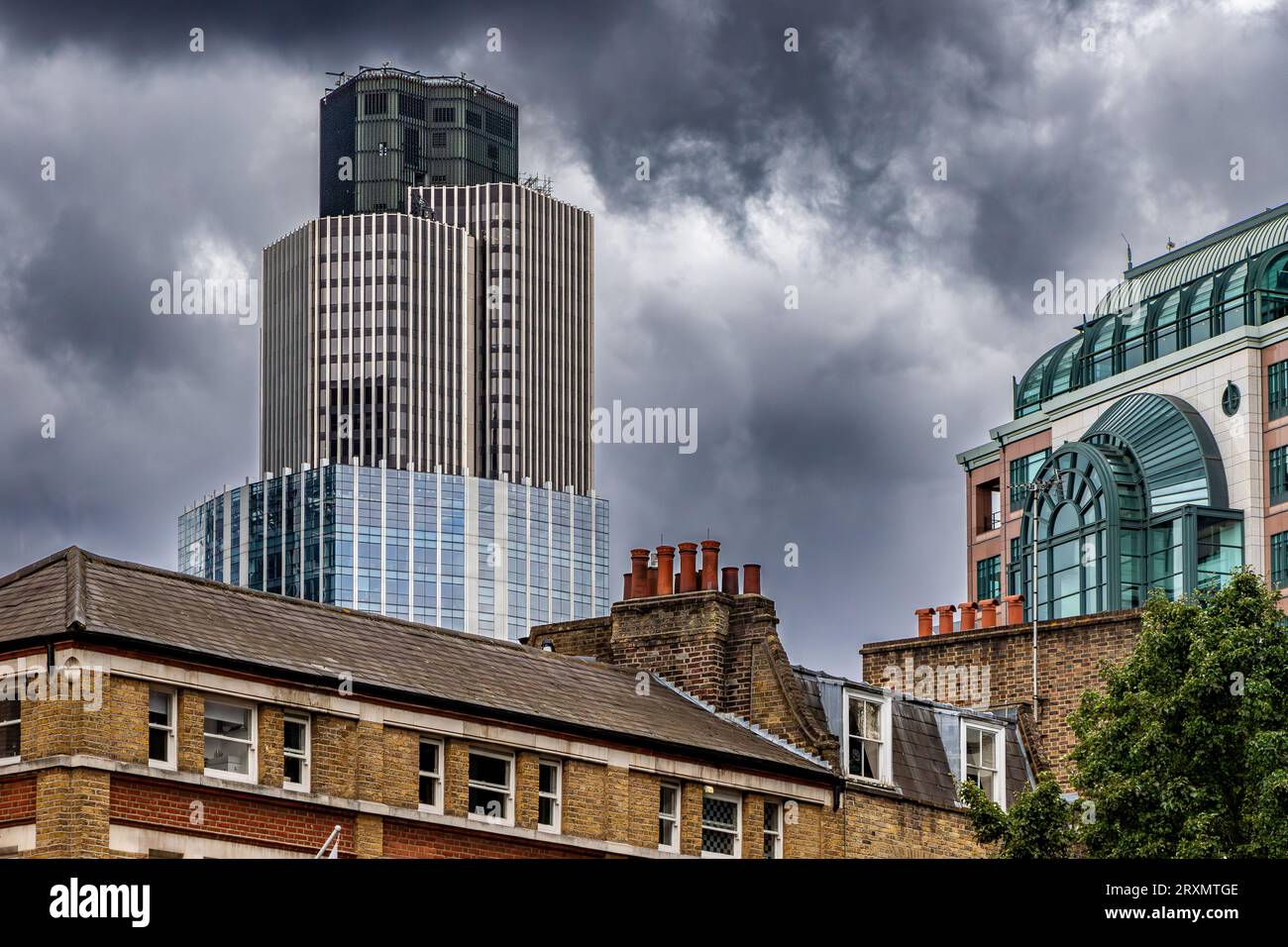 Vor einem bewölkten grauen Himmel ragt der Tower 42, früher bekannt im Nat West Tower, über den Gebäuden von Spitalfields, London, E1 Stockfoto