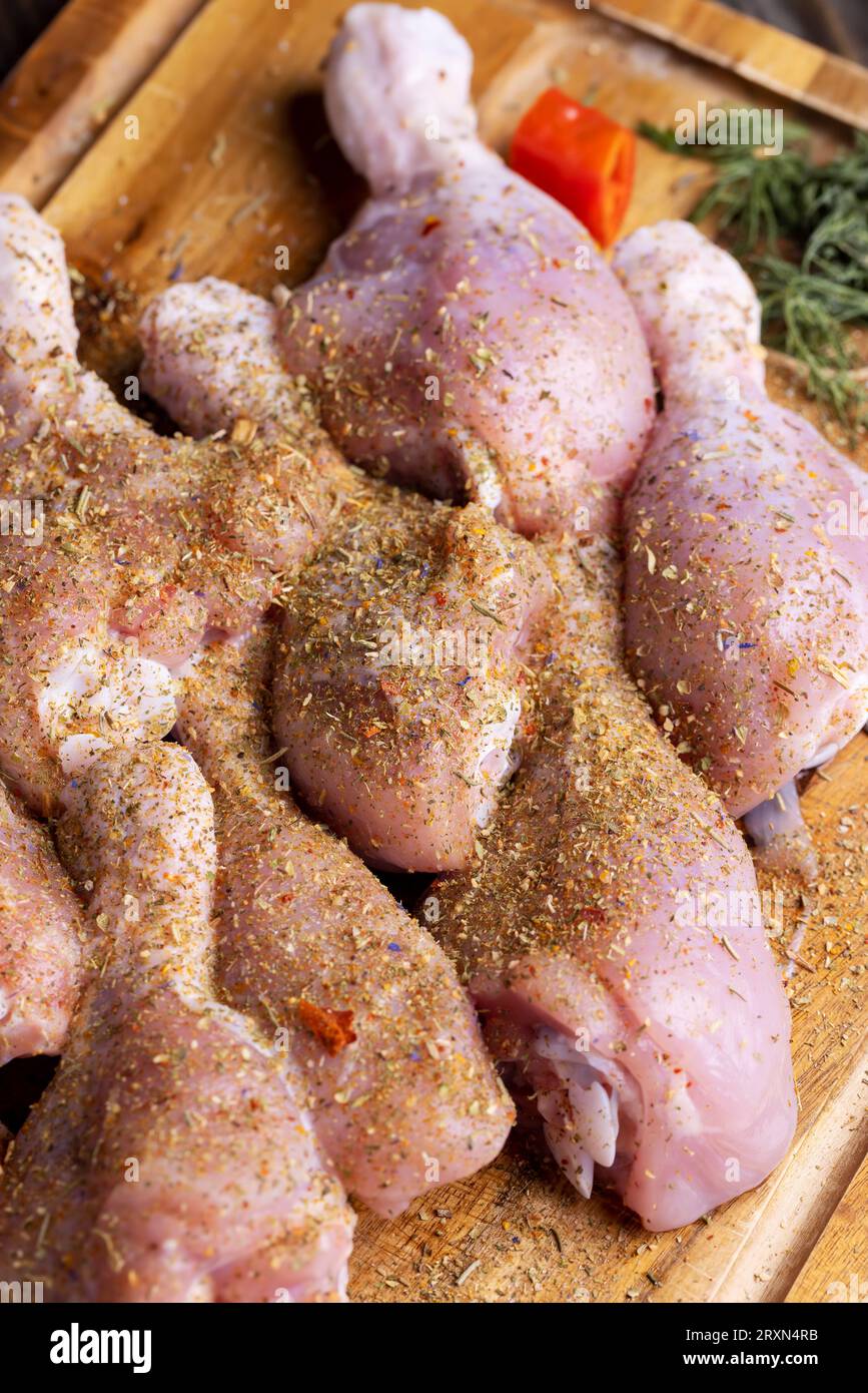 Frisch gewaschenes und gehäutetes Hähnchenfleisch, Hähnchenschenkel mit Salz und Gewürzen zum Kochen Stockfoto
