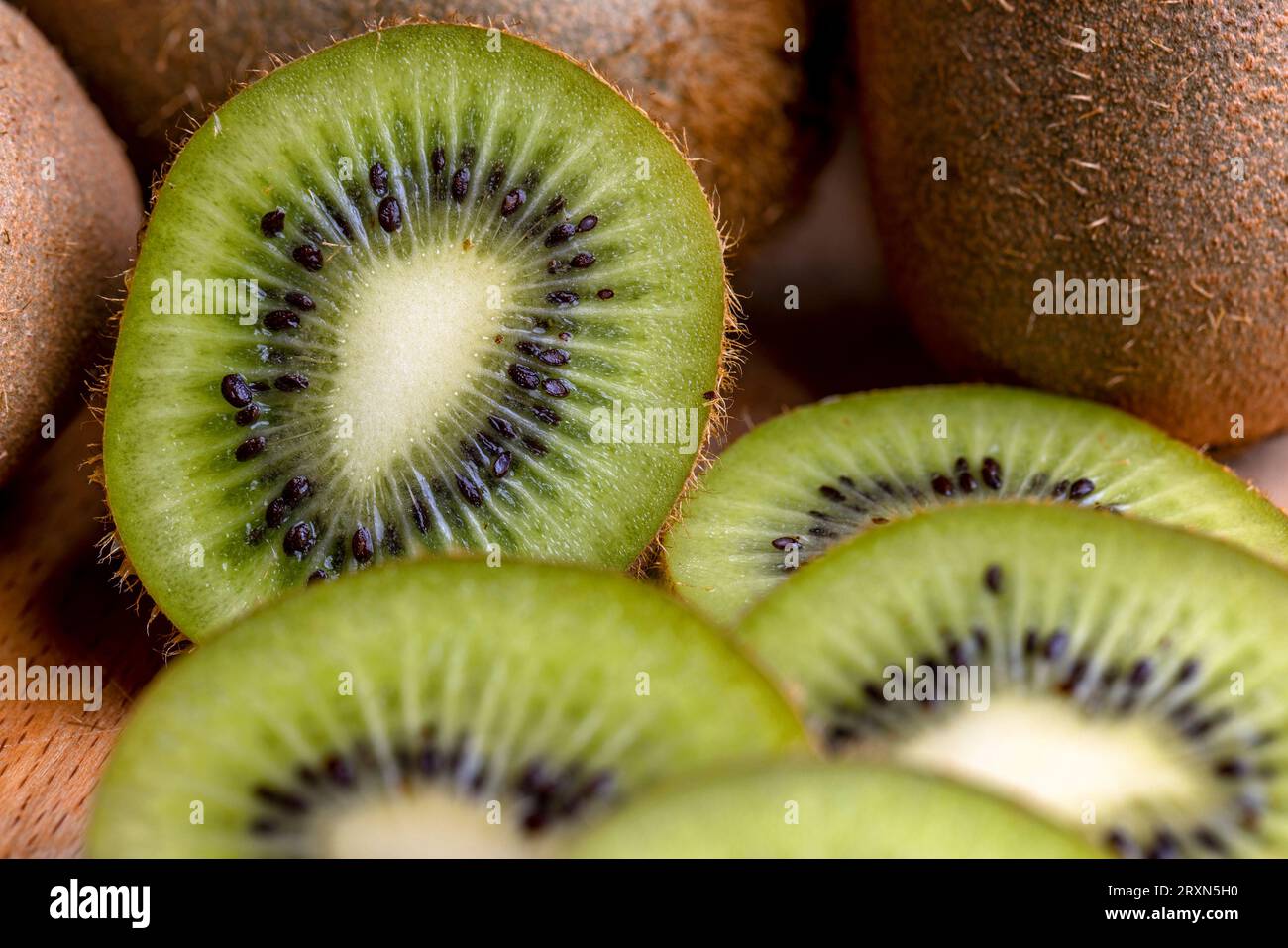 Eine Gruppe geschnittener grüner Kiwifrüchte mit schwarzen Samen, Details von in Stücke geschnittenem grünem Kiwipulp Stockfoto