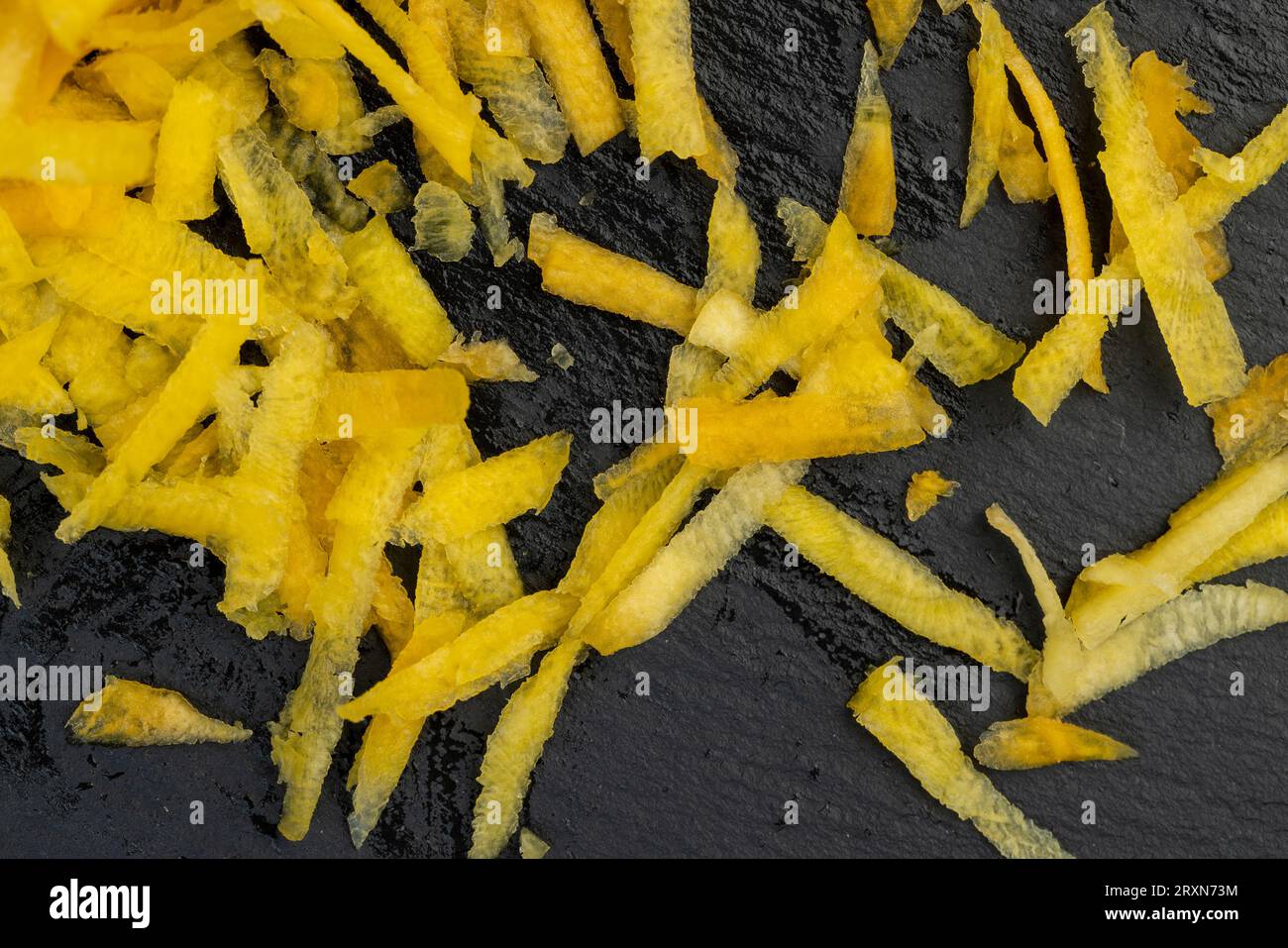 Fein geriebene gelbe Karotten in der Küche, mehrere geschälte und gewaschene Karotten auf einer Reibe in Stücke gerieben Stockfoto