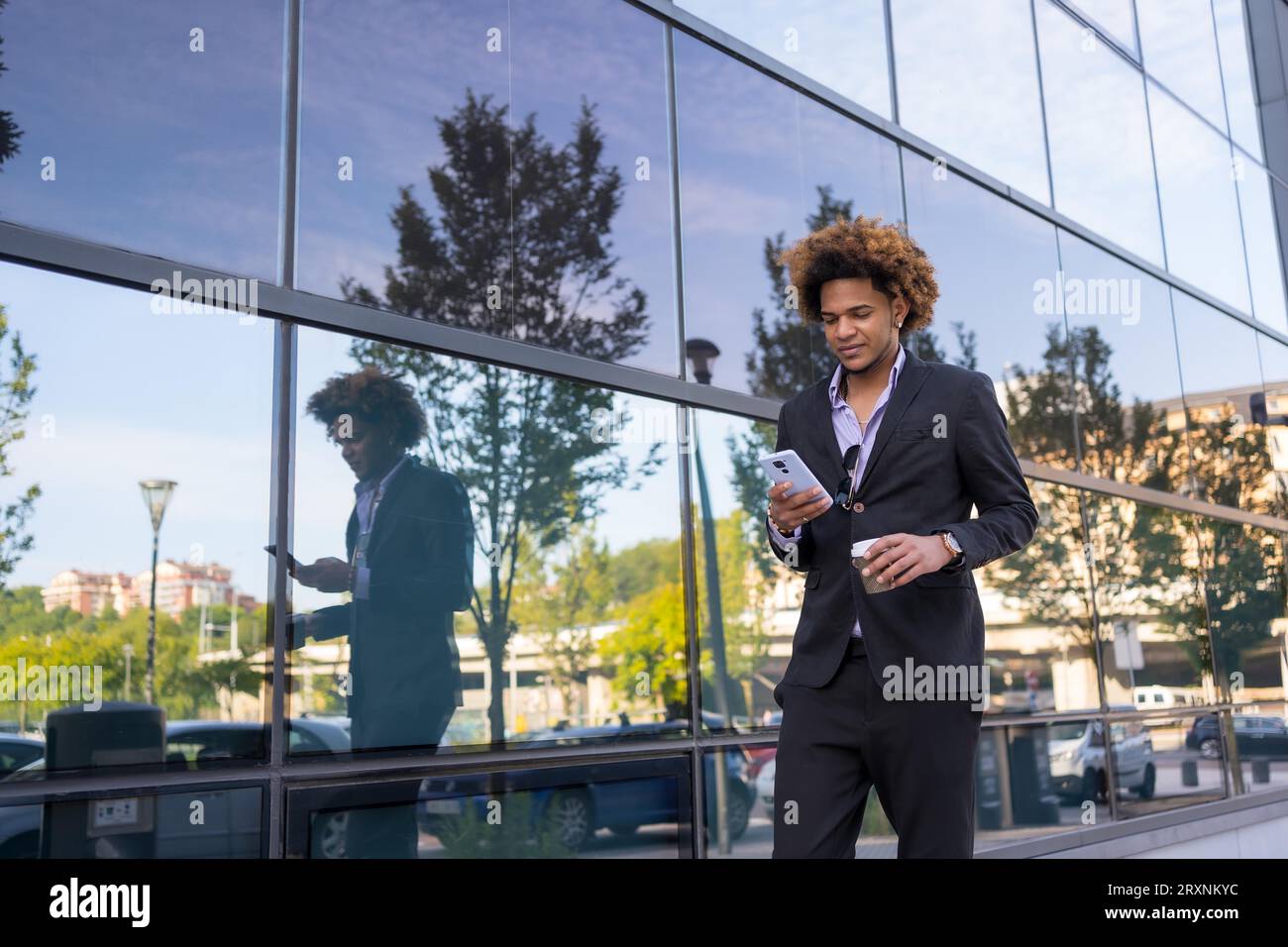 Horizontales Porträt mit Kopienraum eines brünetten Geschäftsmannes, der mit dem Telefon geht und Kaffee trinkt Stockfoto