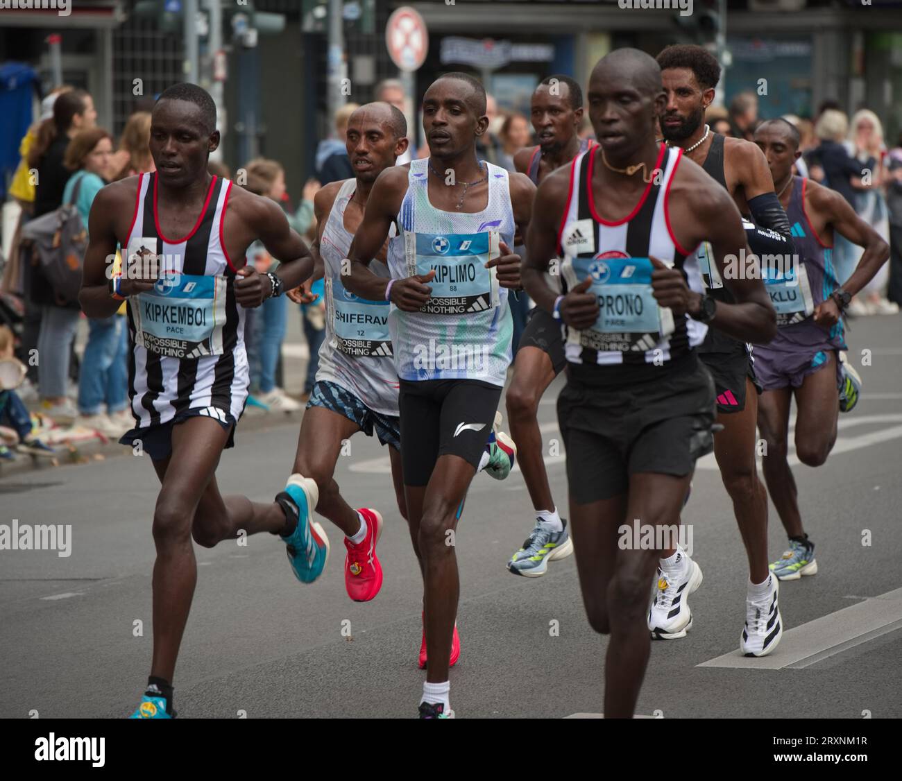 Berlin Marathon 2023 bei Kilometer 25, flankiert von zwei Schrittmachern, die Bonface Kimutai Kiplimo, Startnummer 88, liefen auf Platz zehn, von links auf Platz zwei Stockfoto