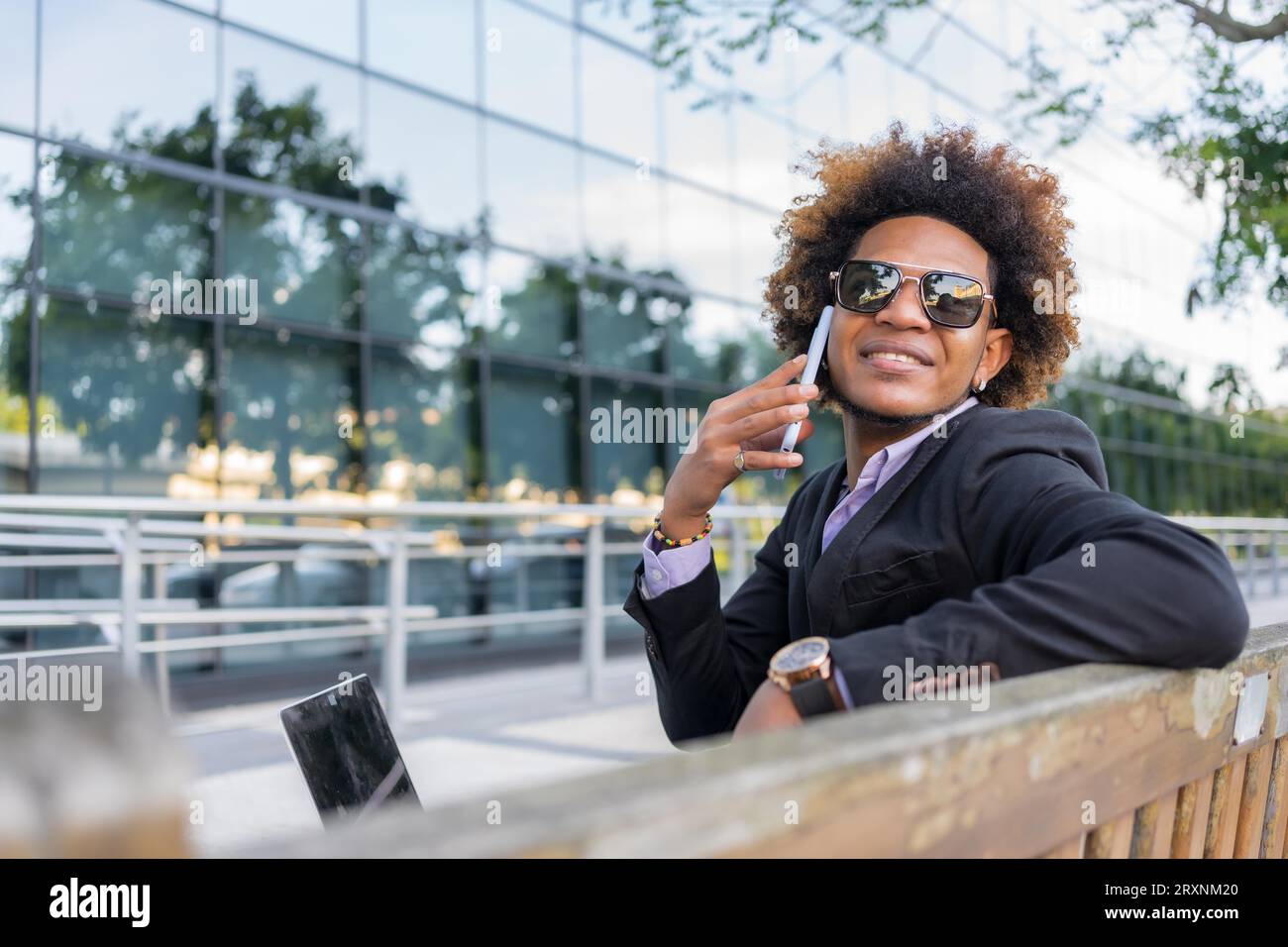 Horizontales Foto mit Kopierraum eines erfolgreichen Geschäftsmannes, der mit dem Mobilgerät im Freien spricht Stockfoto