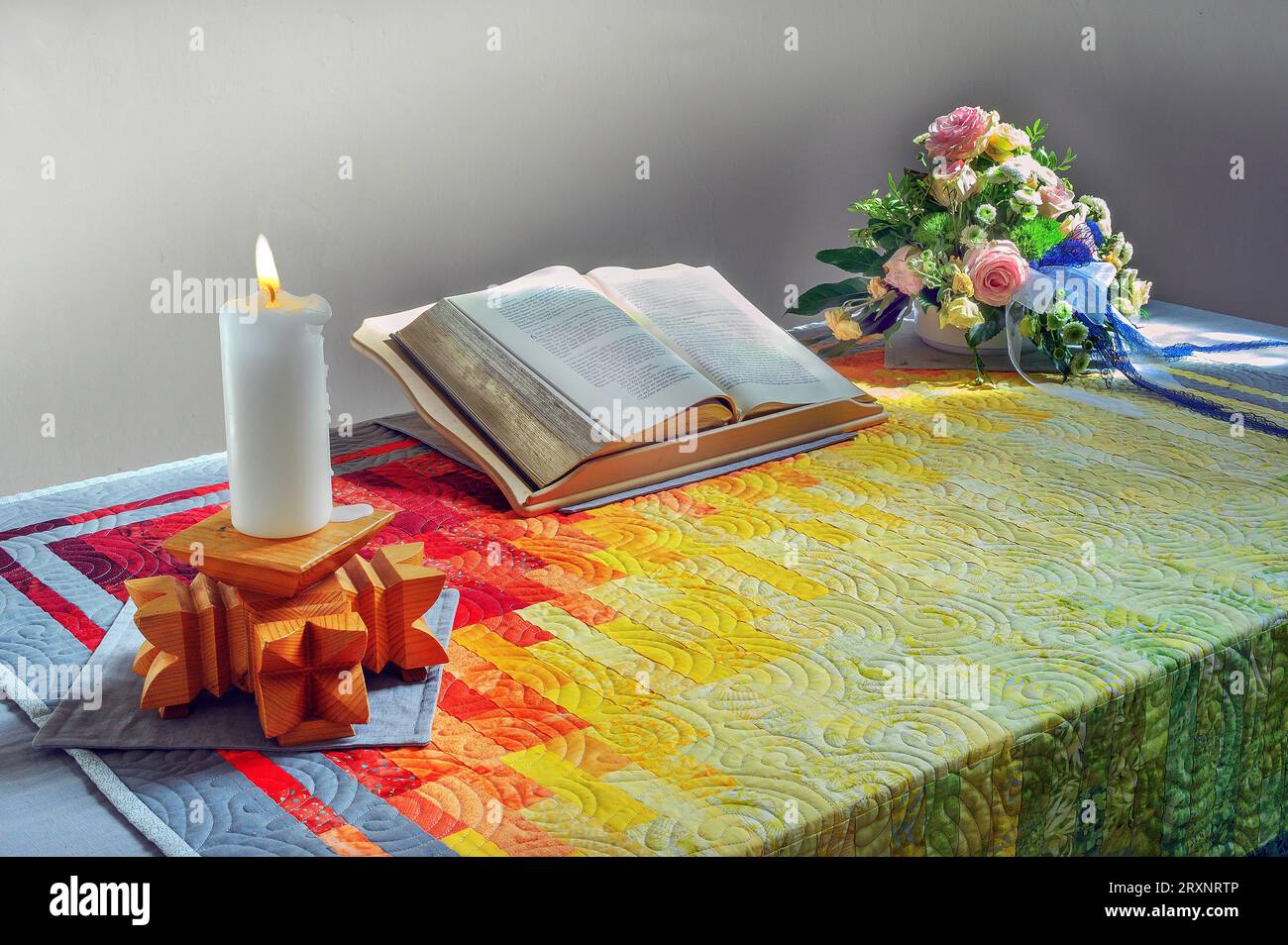 Altar mit Buch, Kerze und Blumendekoration, Spitalkirche, Bad Groenenbach, Allgaeu, Bayern, Deutschland Stockfoto