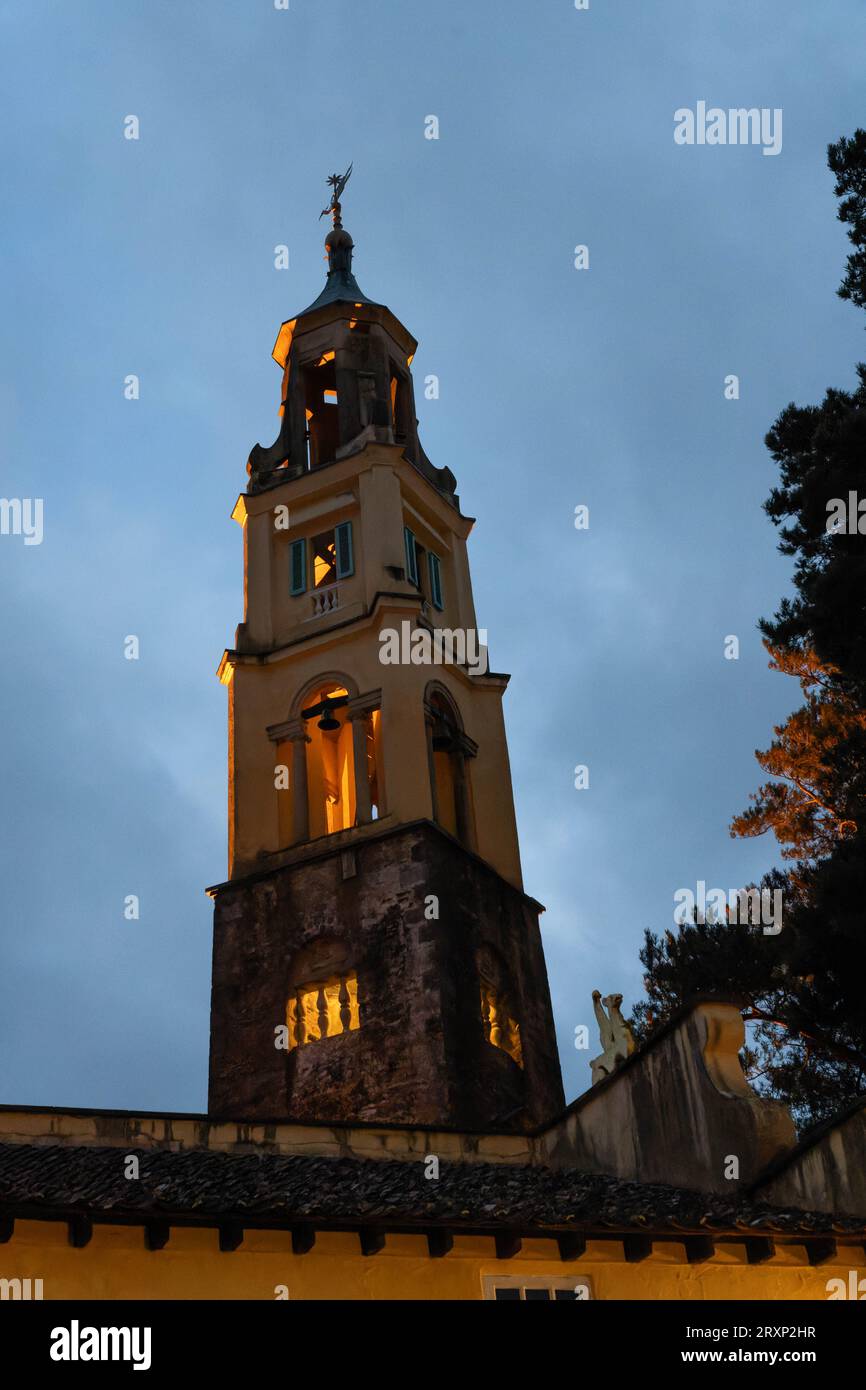 Beleuchteter Glockenturm in der Abenddämmerung im Dorf Portmeirion, Nordwales Stockfoto