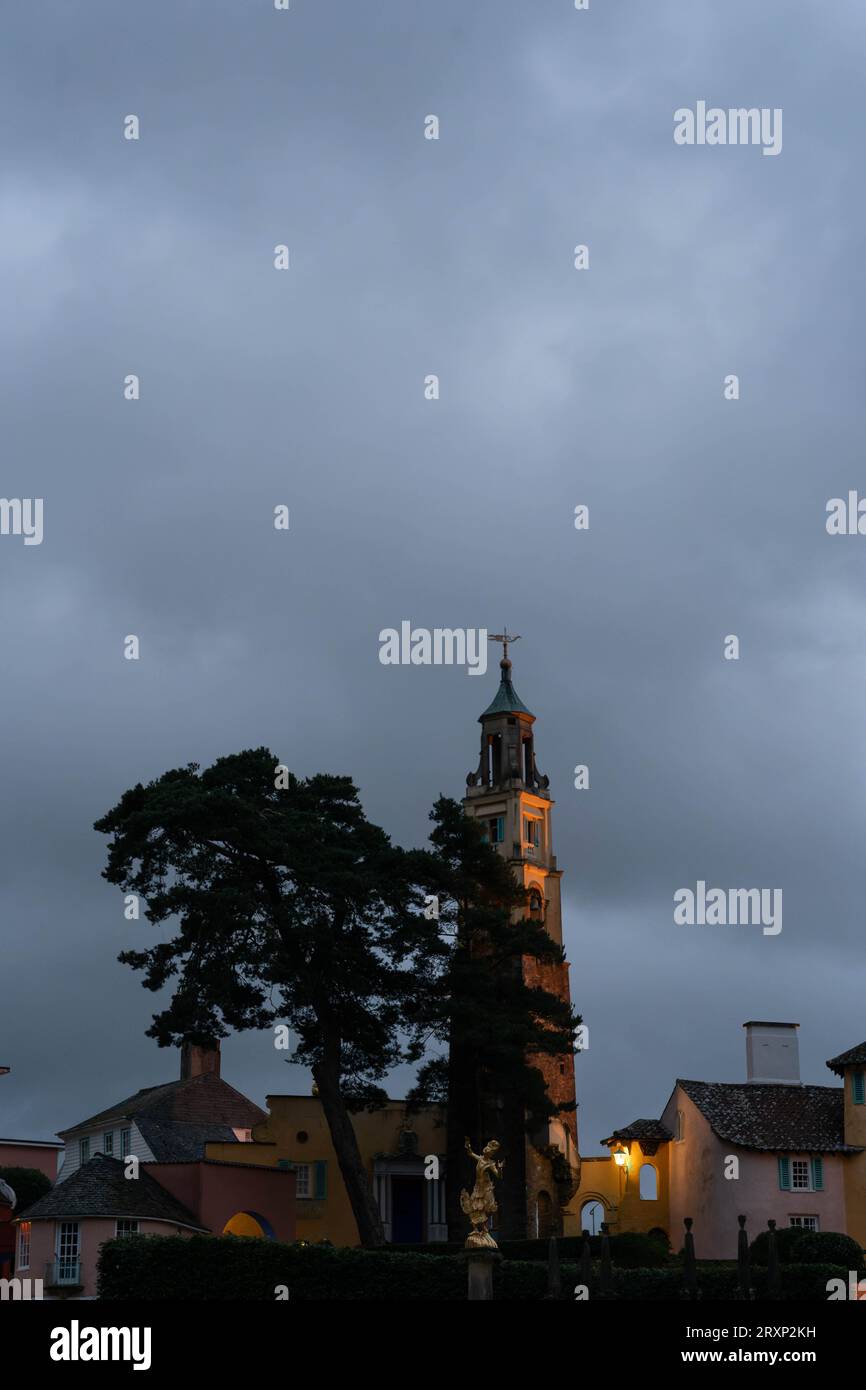 Beleuchteter Glockenturm und farbenfrohe Gebäude in der Abenddämmerung im Dorf Portmeirion Stockfoto