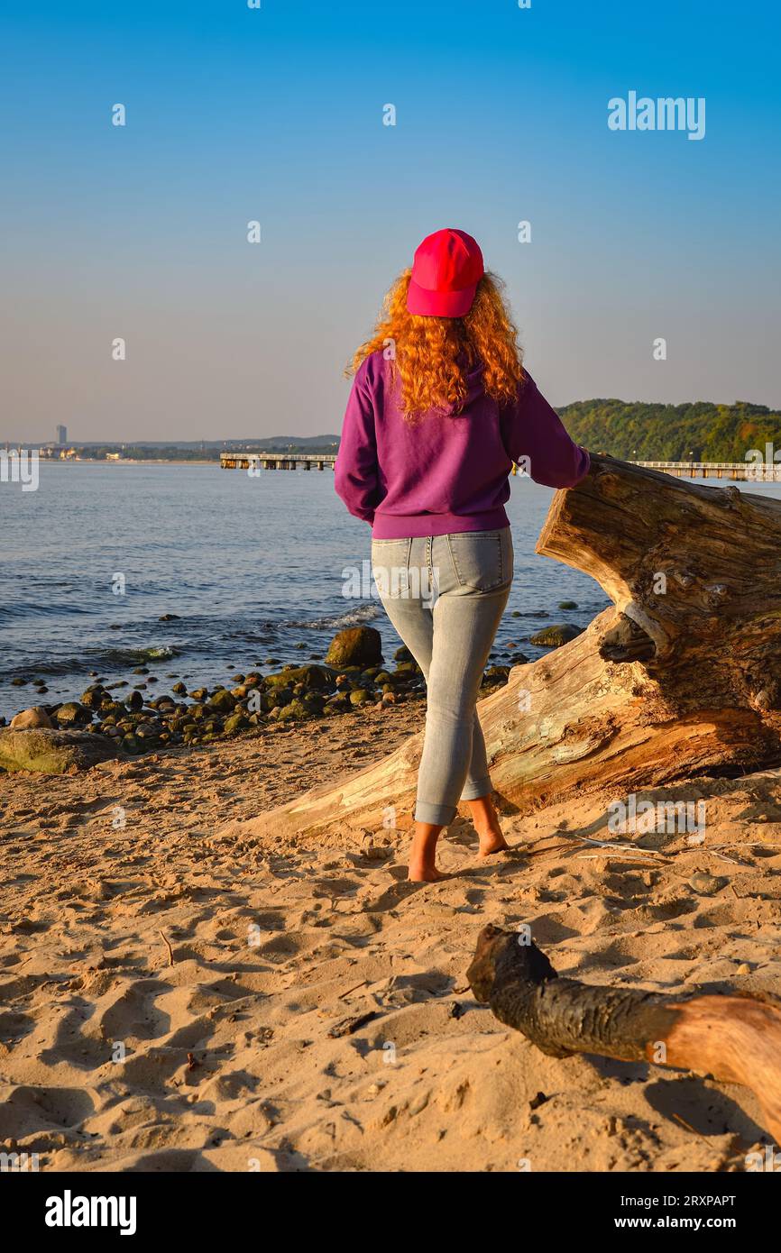 Morgenszene mit einer Frau am Strand. Weibliche Touristen am Strand von Gdynia an der Ostsee in Polen, die die Aussicht bewundern. Stockfoto