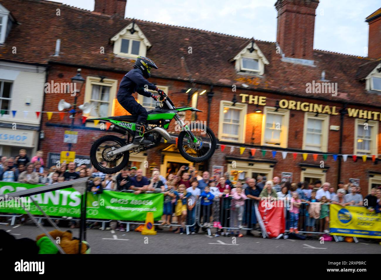 Motorrad-Stunt-Fahrer startet von einer Rampe in Ringwood Carnival, Hampshire, Großbritannien, September 2023 Stockfoto