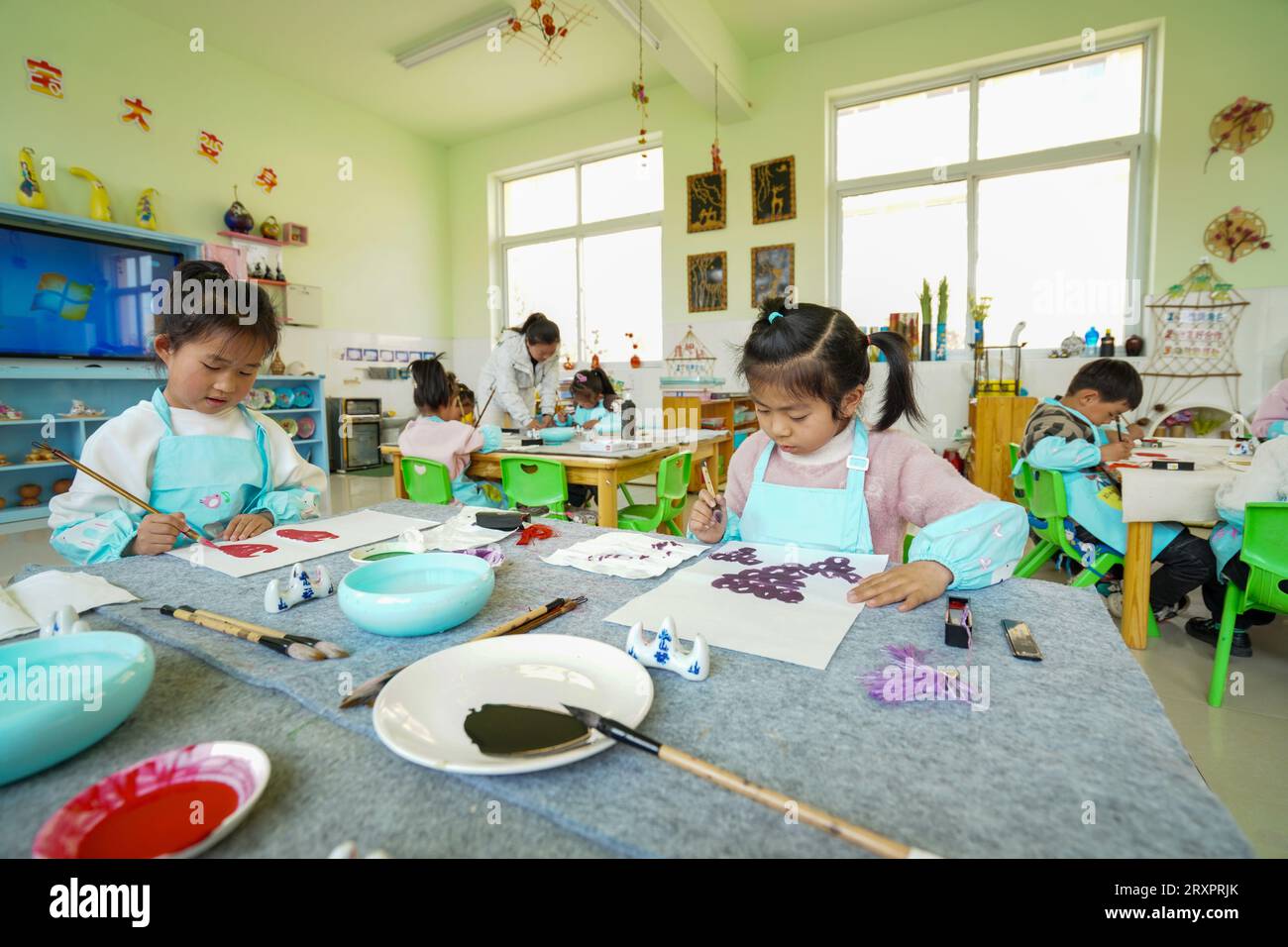 Luannan County, China - 25. April 2023: Kindergartenkinder machen Obst- und Gemüsedrucke Stockfoto