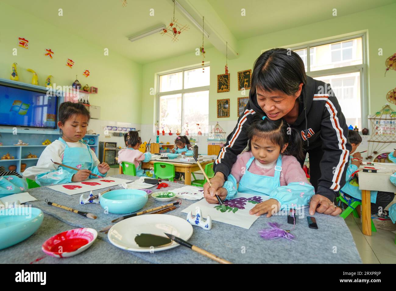 Luannan County, China - 25. April 2023: Kindergartenkinder machen Obst- und Gemüsedrucke Stockfoto