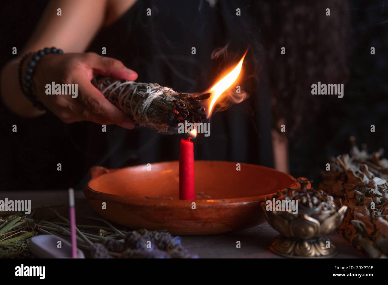 Ein Weihrauch anzünden, eine Hexe am Vorabend aller Heiligen, die ein Reinigungsritual durchführt, Halloween, spirituelle Überzeugungen, weiße Magie Stockfoto