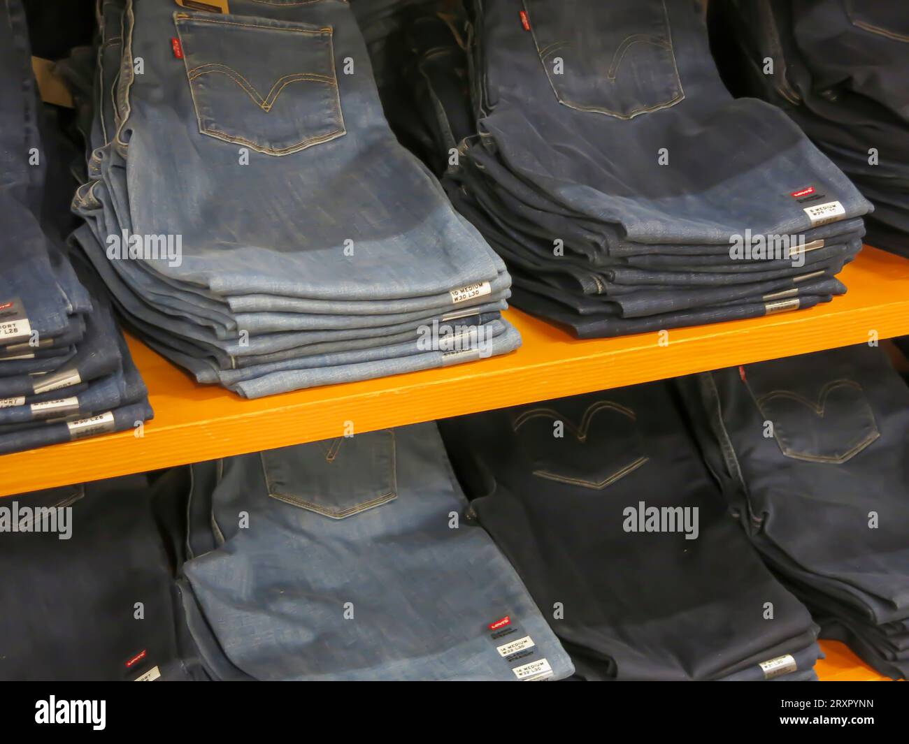 Jeans gefaltet und in Regalen im Einzelhandel ausgestellt Stockfoto