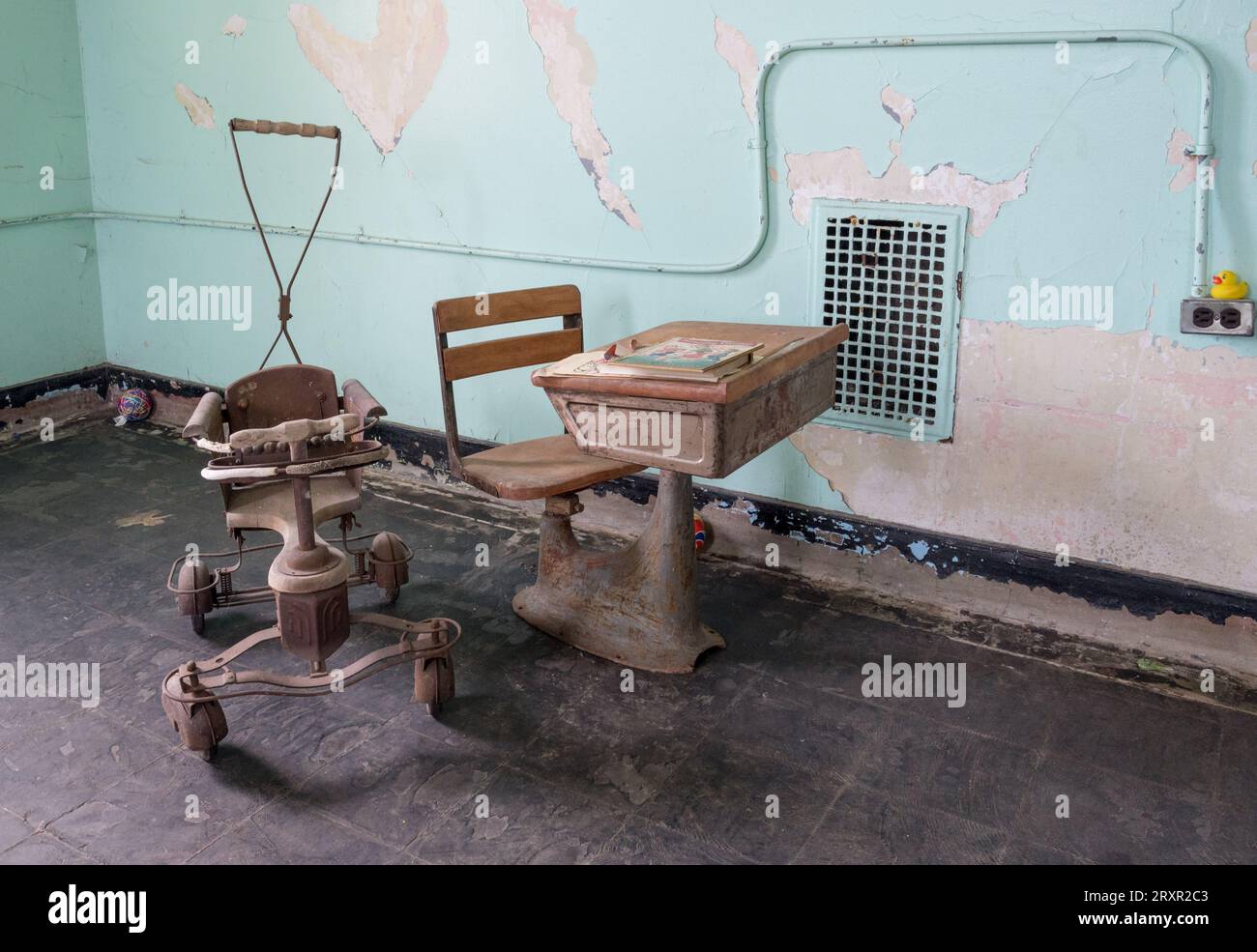 Kinderroller und Schultisch im verlassenen Trans Allegheny Lunatic Asylum in Weston, West Virginia Stockfoto
