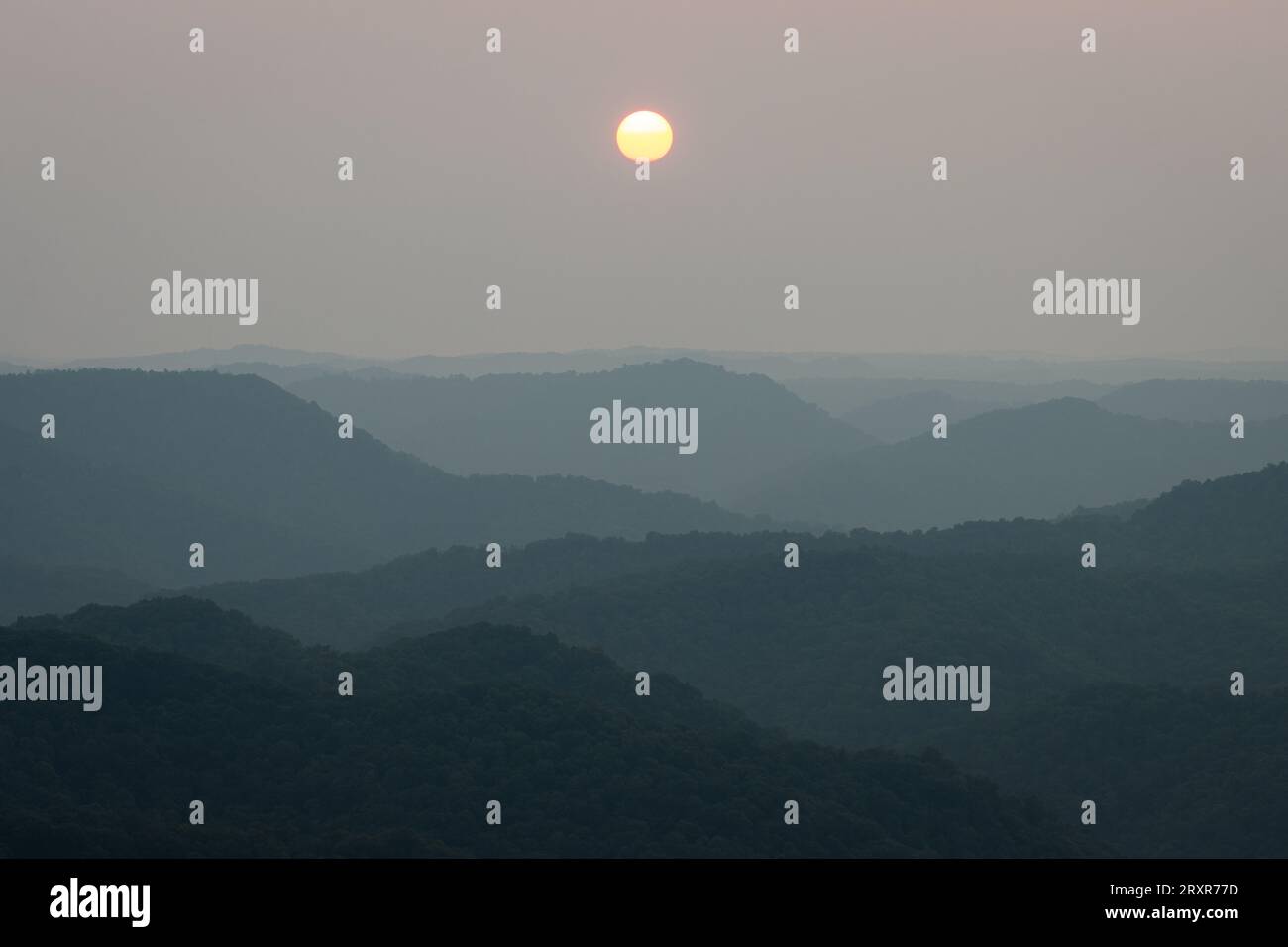 Die Sonne untergeht über Bergrücken. Stockfoto