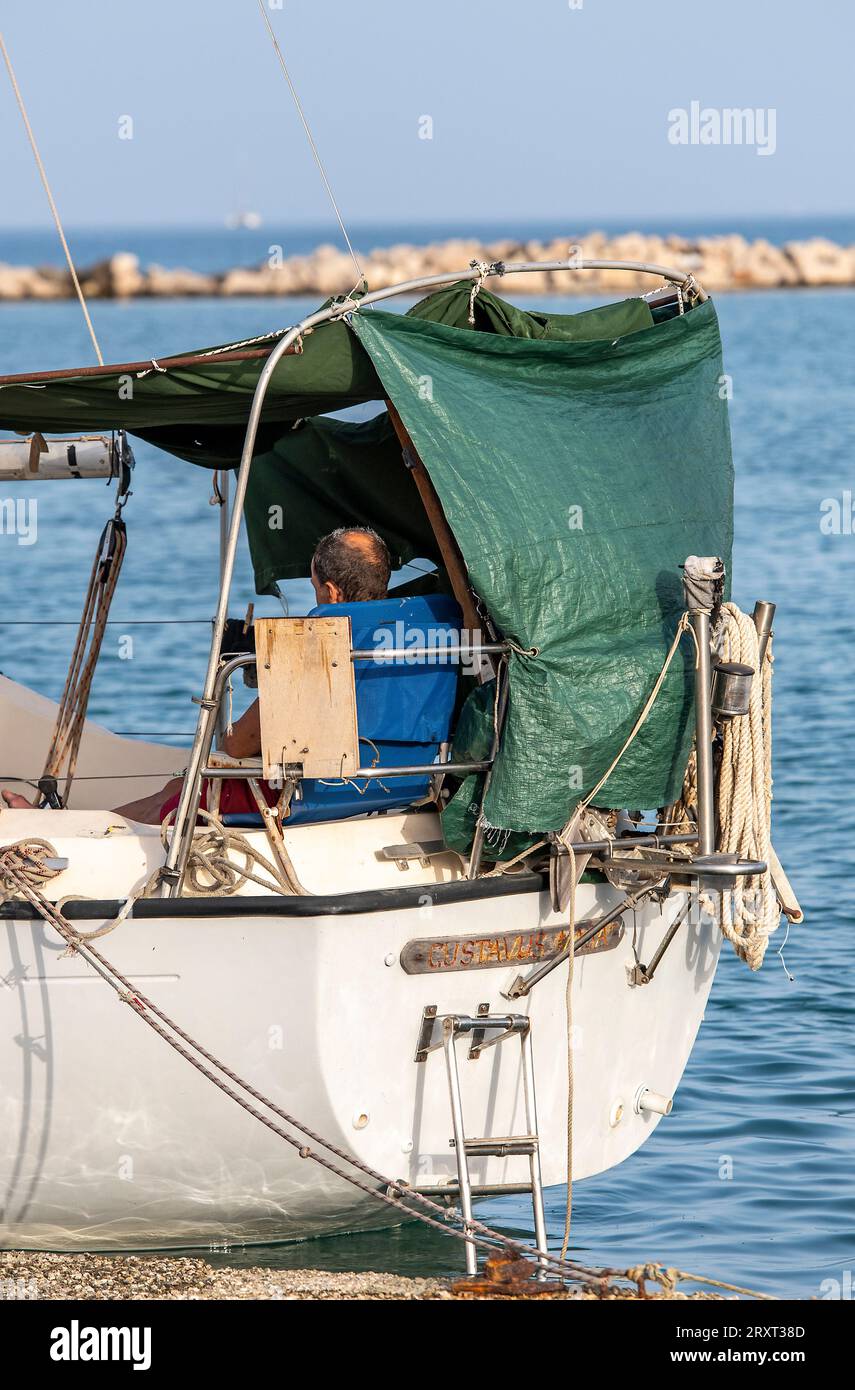 Mann sitzt auf einer alten Jacht im Hafen von zante, zakynthos, griechenland Stockfoto