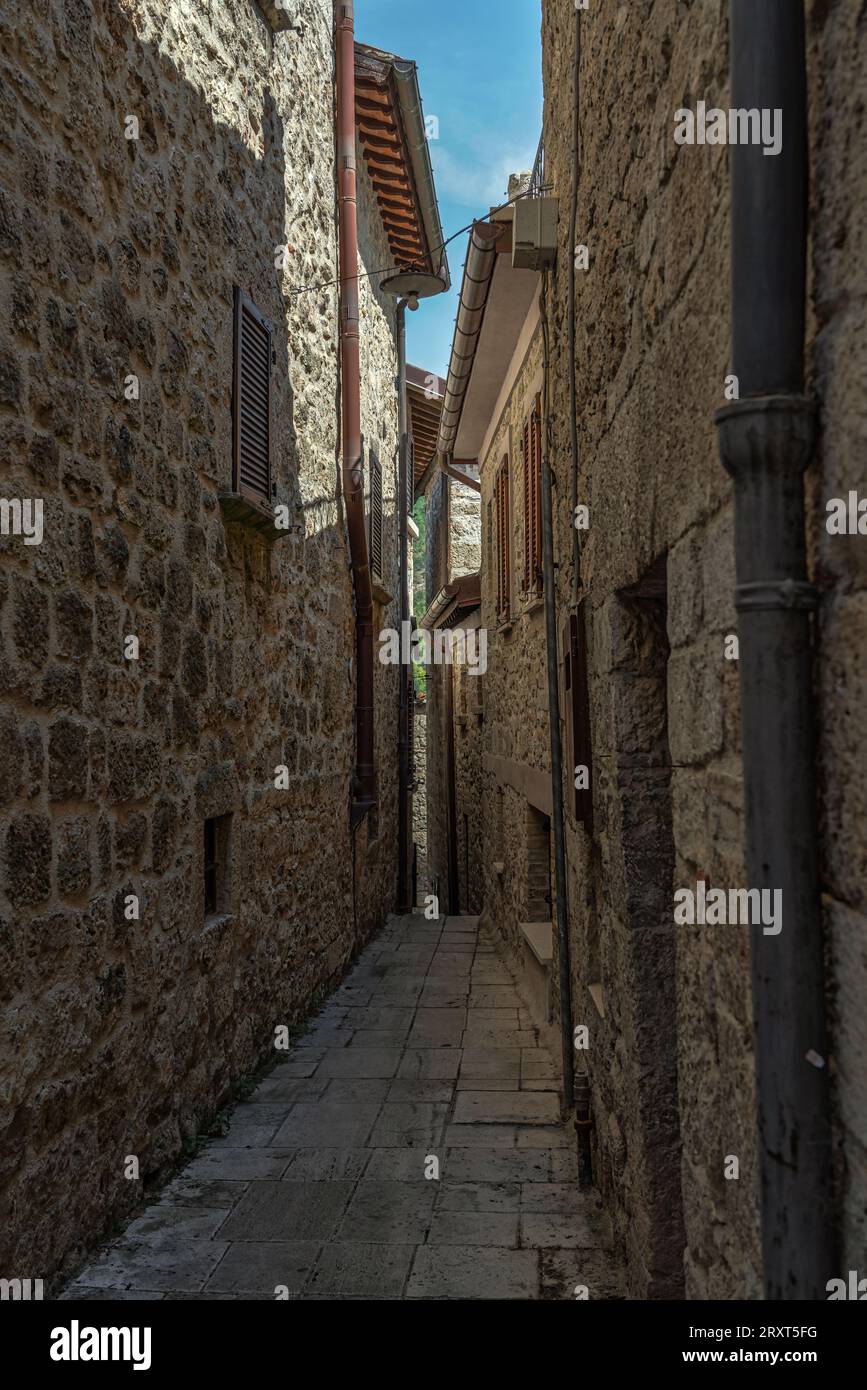Gassen und Treppen zwischen Steinhäusern und bunten Blumenkästen im mittelalterlichen Dorf Castel Trosino. Ascoli Piceno, Region Marken, Stockfoto