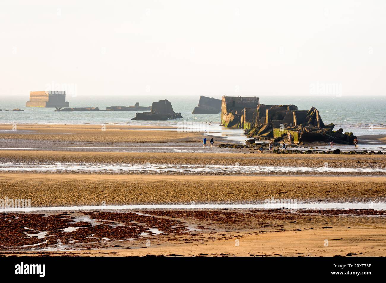Überreste von Phoenix Caissons auf dem Sand, die nach den Landungen in der Normandie im Zweiten Weltkrieg zum Bau des Mulberry-Hafens am Gold Beach in Arromanches, Frankreich, verwendet wurden. Stockfoto