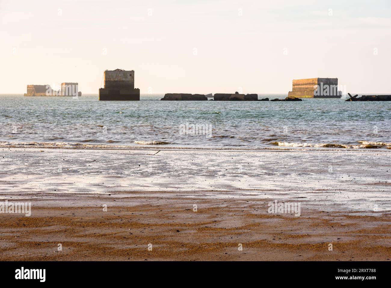 Überreste von Phönix-Caissons bauten nach den Landungen in der Normandie im Zweiten Weltkrieg den künstlichen Mulberry-Hafen am Gold Beach in Arromanches, Frankreich. Stockfoto