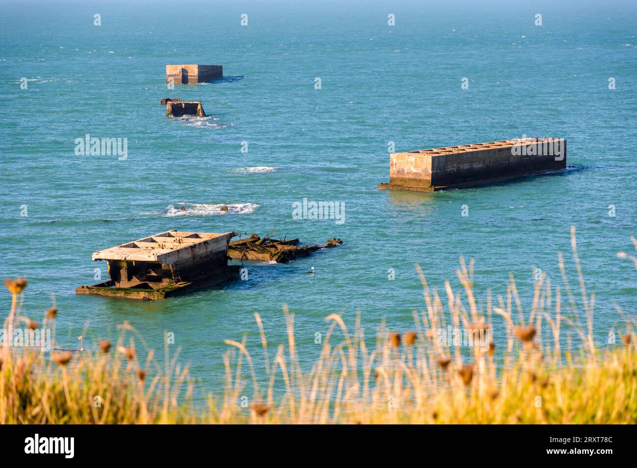 Überreste von Phönix-Caissons bauten nach den Landungen in der Normandie im Zweiten Weltkrieg den künstlichen Mulberry-Hafen am Gold Beach in Arromanches, Frankreich. Stockfoto