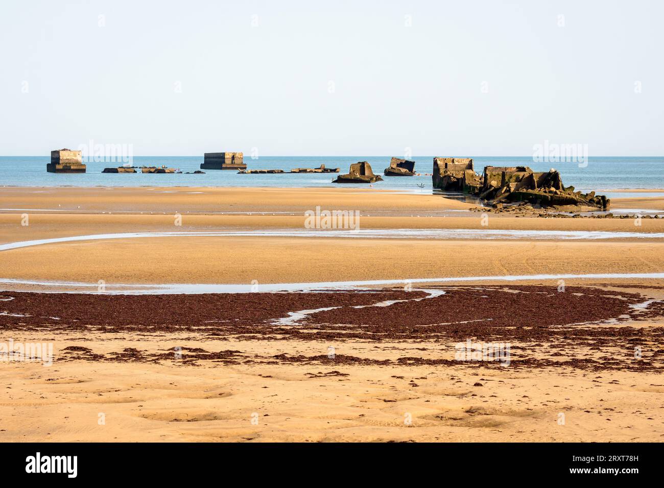 Überreste von Phoenix Caissons auf dem Sand, die nach den Landungen in der Normandie im Zweiten Weltkrieg zum Bau des Mulberry-Hafens am Gold Beach in Arromanches, Frankreich, verwendet wurden. Stockfoto