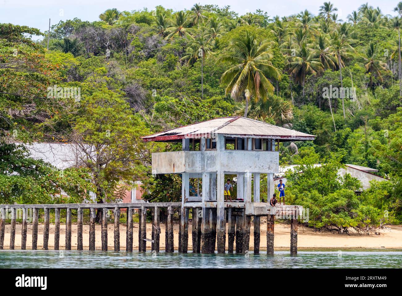 Junge Männer fischen von einem lokalen Gebäude auf Bangka Island, vor der nordöstlichen Spitze von Sulawesi, Indonesien, Südostasien, Asien Stockfoto
