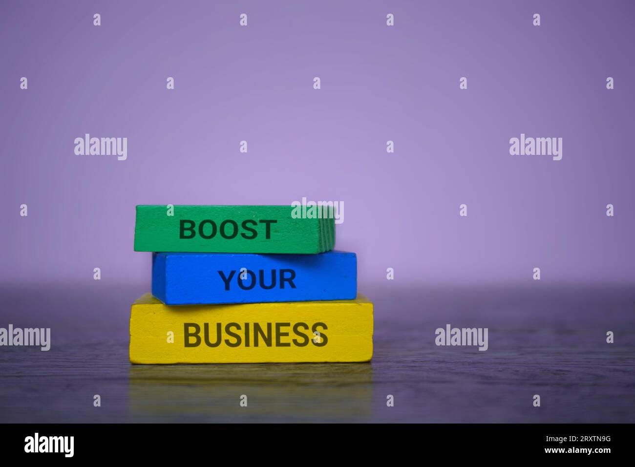 Holzfliesen mit Text STEIGERN IHR GESCHÄFT auf violettem Hintergrund. Geschäftskonzept. Stockfoto