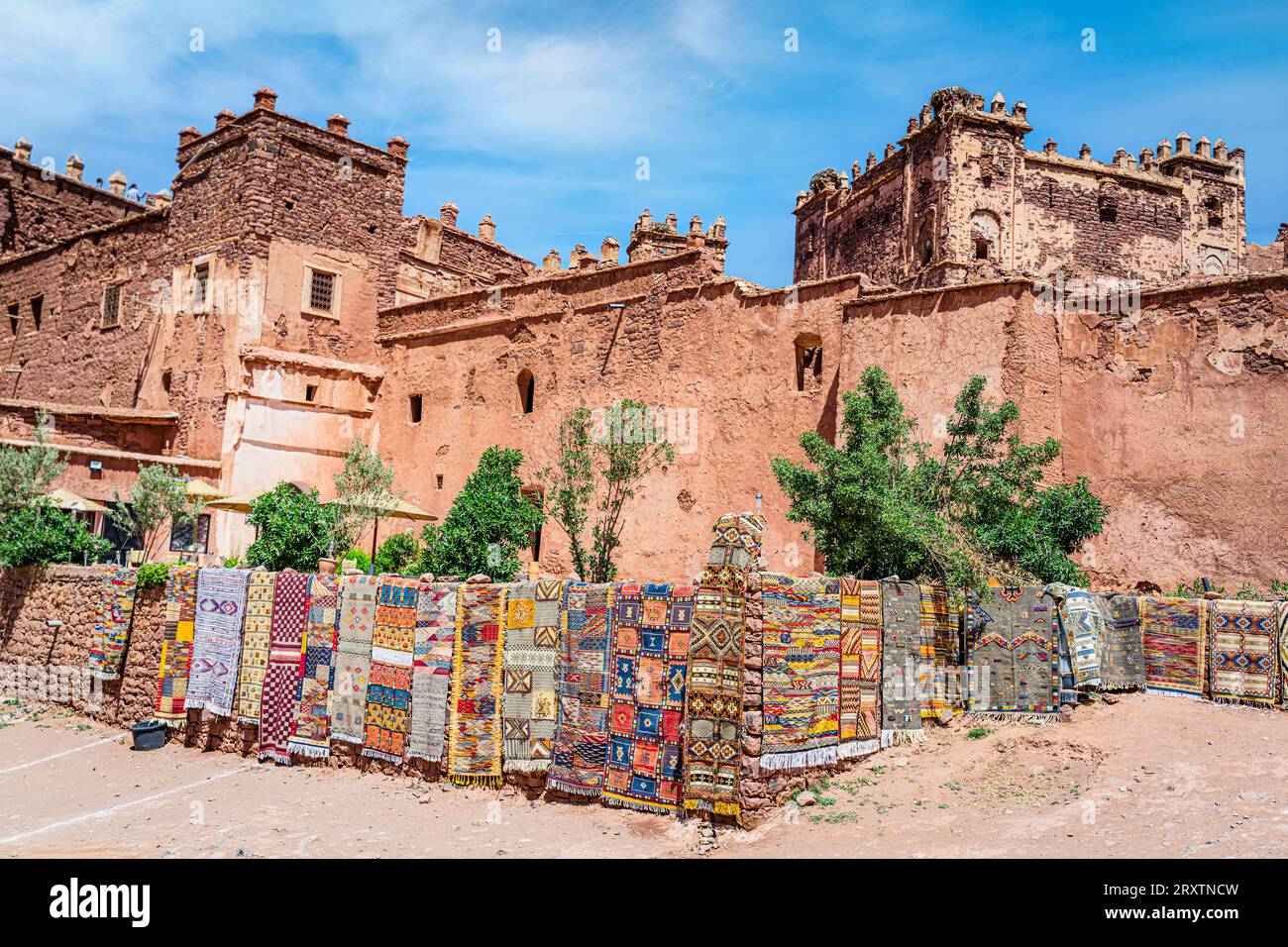 Bunte handgefertigte Teppiche zum Verkauf hängen vor den alten Ruinen von Telouet Kasbah, Hohen Atlas Berge, Marokko, Nordafrika, Afrika Stockfoto