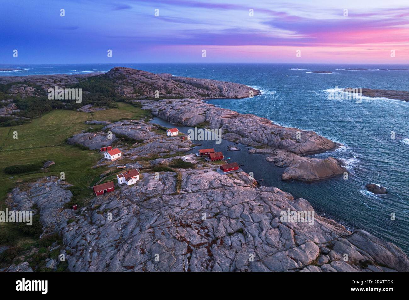 Aus der Vogelperspektive auf die malerische Landschaft aus Granitfelsen mit abgelegenen Häusern und roten Hütten entlang der Küste, Ramsvik Insel, Bohuslan Stockfoto