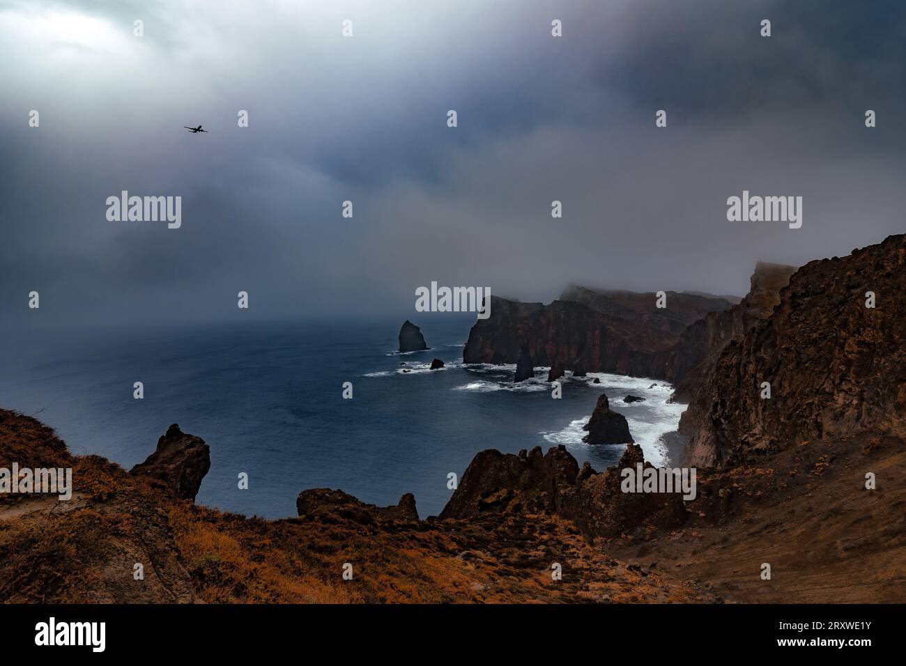 Blick auf die felsige Landschaft der Halbinsel Ponta de São Lourenco auf Madeira, Portugal, bei schlechtem Wetter, mit einem Flugzeug auf Landeanflug nach Funchal Stockfoto