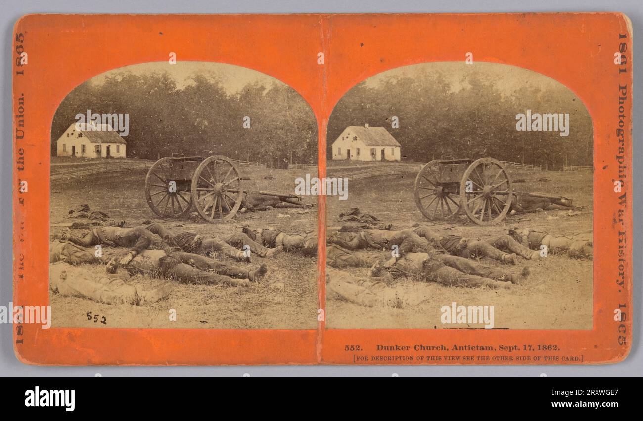 Dieser Albumdruck-Stereograph zeigt mehrere verstorbene Soldaten, die auf einem Feld im Vordergrund liegen. Die Körper befinden sich unmittelbar vor einem Wagen mit großen Holzrädern und einem Kofferraum auf dem Sitz. Im linken Hintergrund befindet sich ein weißes Gebäude, die Dunker Church, mit Schäden an dem Gebäude durch Artillerie an den Seiten und auf dem Dach. Pferde stehen vor dem Gebäude. Ein hölzerner Zaun verläuft zwischen der Kirche und der Gruppierung von Leichen und Wagen im Vordergrund. Die Fotos sind mit einem abgerundeten oberen Rand geschnitten. Auf der linken Seite der orangefarbenen Pappbefestigung steht „1861 DER KRIEG FÜR Stockfoto