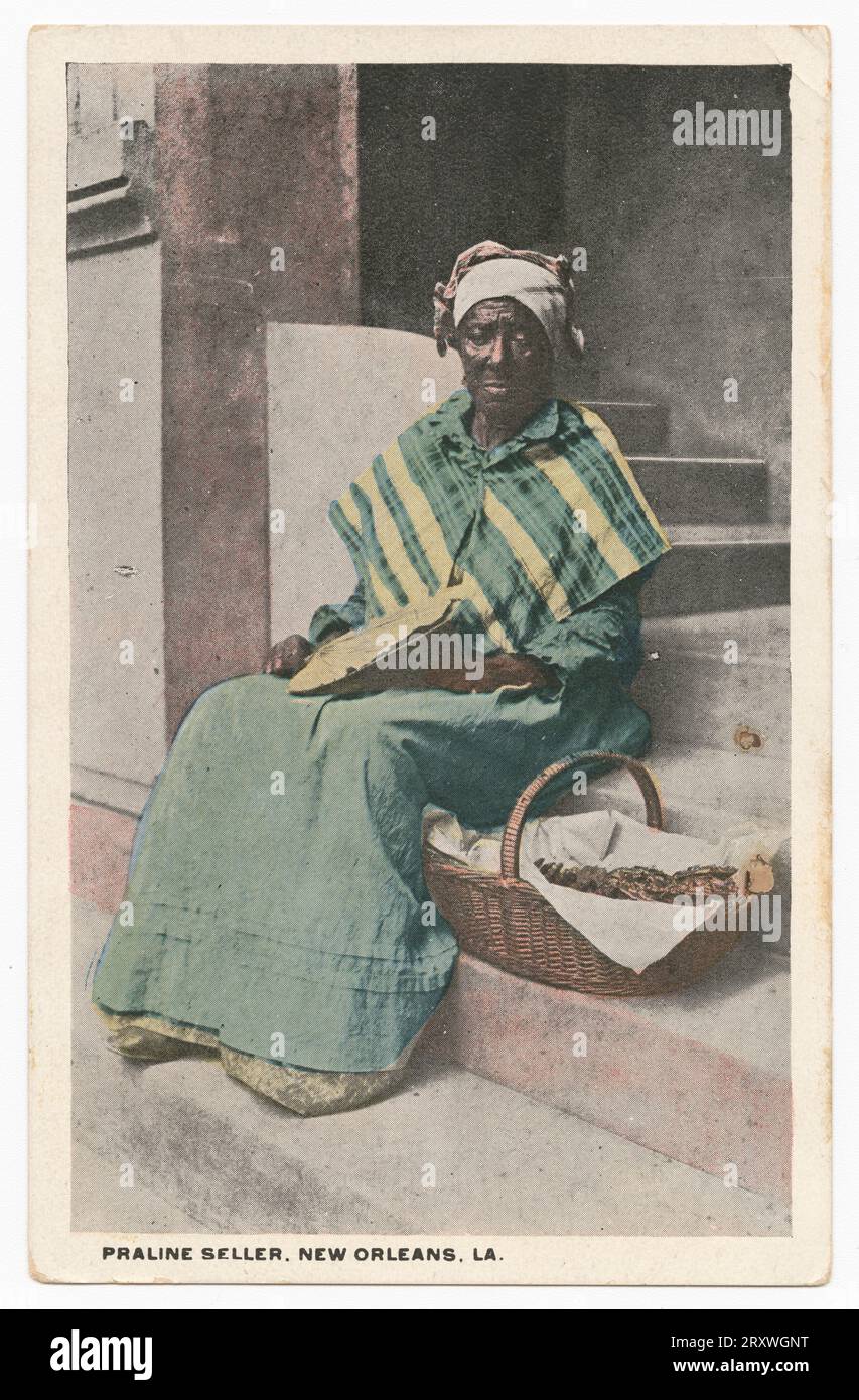 Vertikal ausgerichtete Postkarte mit einem getönten Bild einer Schwarzweißfotografie einer Frau, die auf geschwungenen Treppen sitzt. Die Frau sitzt mit einem Ventilator in ihrer rechten Hand, der auf ihrem Schoß ruht. Auf ihrer linken Seite, auf der Stufe unter ihr, befindet sich ein Korb mit Nahrung. Sie trägt ein grün-gelbes Kleid und eine Kopfbedeckung. Unter dem Bild in der unteren linken Ecke befindet sich der schwarze Text „PRALINE SELLER, NEW ORLEANS, LA“. Die Rückseite der Postkarte ist in zwei Portionen unterteilt und hat durchgehend einen grünen Text „PRALINÉ VERKÄUFER-Pralinen sind ein Bonbon aus hellbraunem Zucker, der dick mit Fleisch des Pec bestreut ist Stockfoto