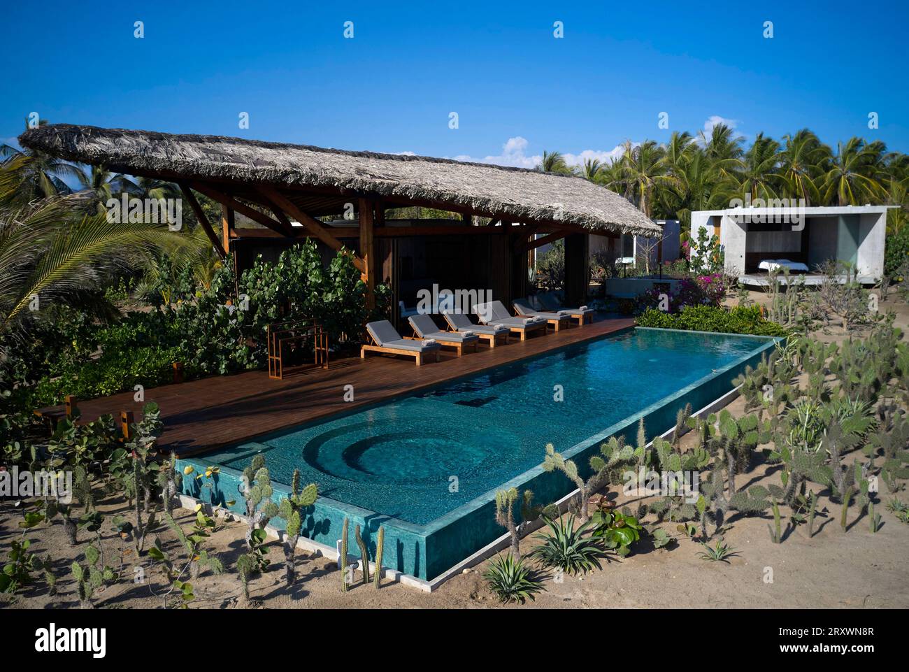 Blick auf das Haupthaus mit Strohdach und Pool. Casa Leria, Puerto Escindido, Mexiko. Architekt: TAC Taller Alberto Calleja, 2023. Stockfoto