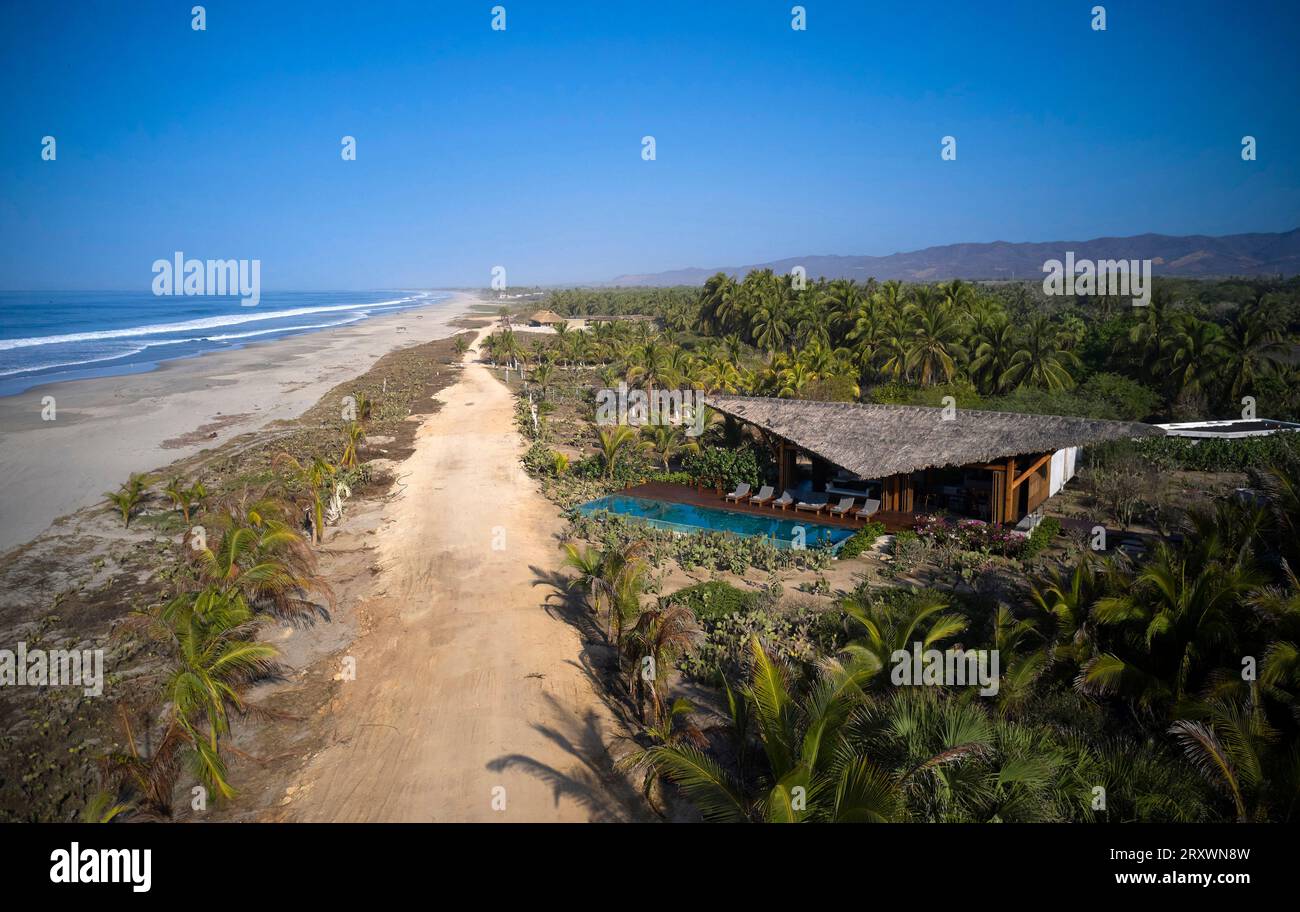 Blick aus der Vogelperspektive auf Ferienhaus und Strand. Casa Leria, Puerto Escindido, Mexiko. Architekt: TAC Taller Alberto Calleja, 2023. Stockfoto