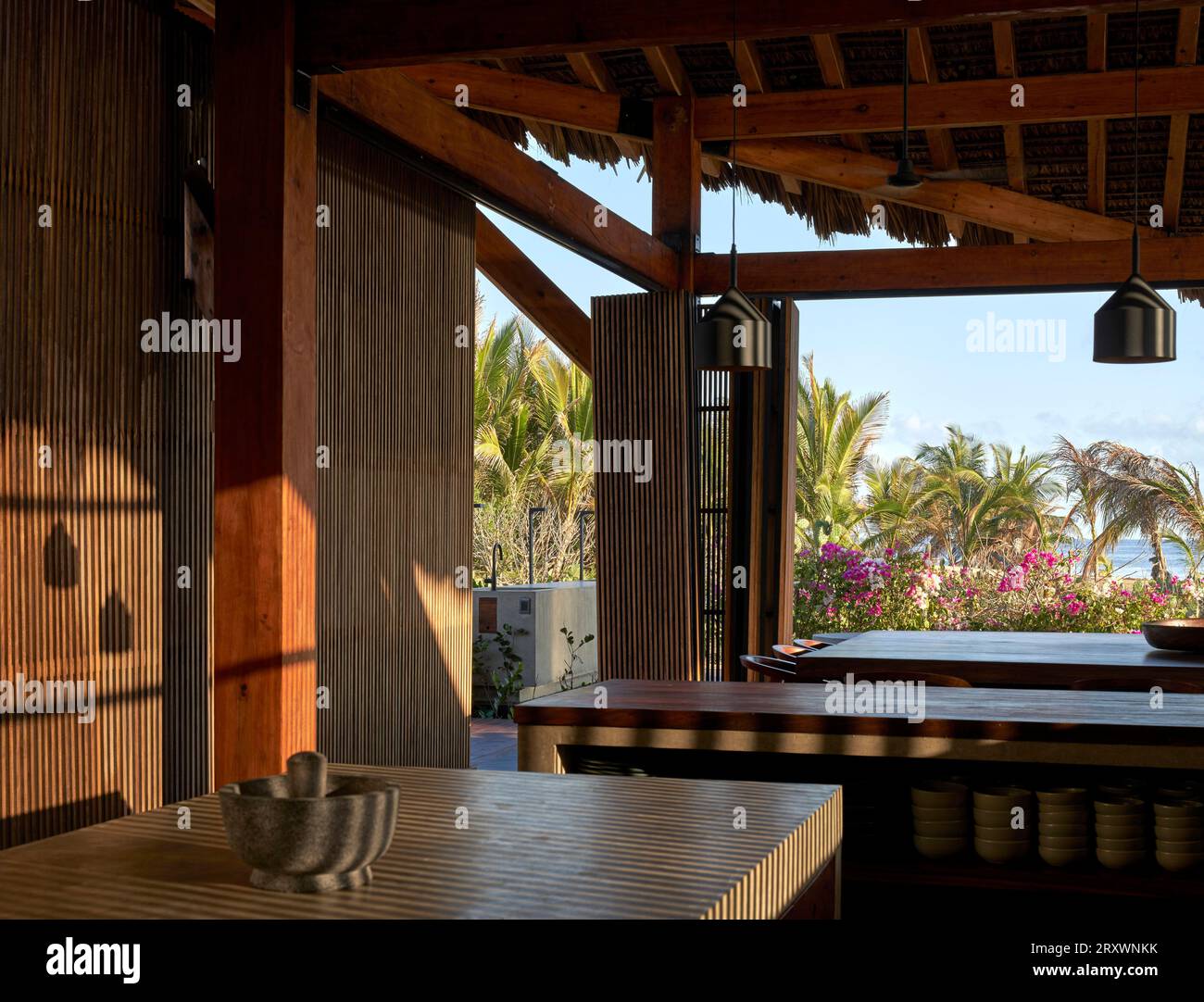 Offene Küche und Essbereich mit Blick auf den Strand. Casa Leria, Puerto Escindido, Mexiko. Architekt: TAC Taller Alberto Calleja, 2023. Stockfoto