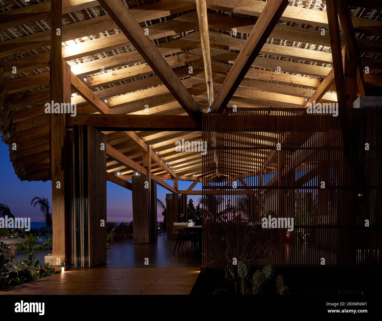 Blick in die Abenddämmerung mit Palapa-Decke. Casa Leria, Puerto Escindido, Mexiko. Architekt: TAC Taller Alberto Calleja, 2023. Stockfoto