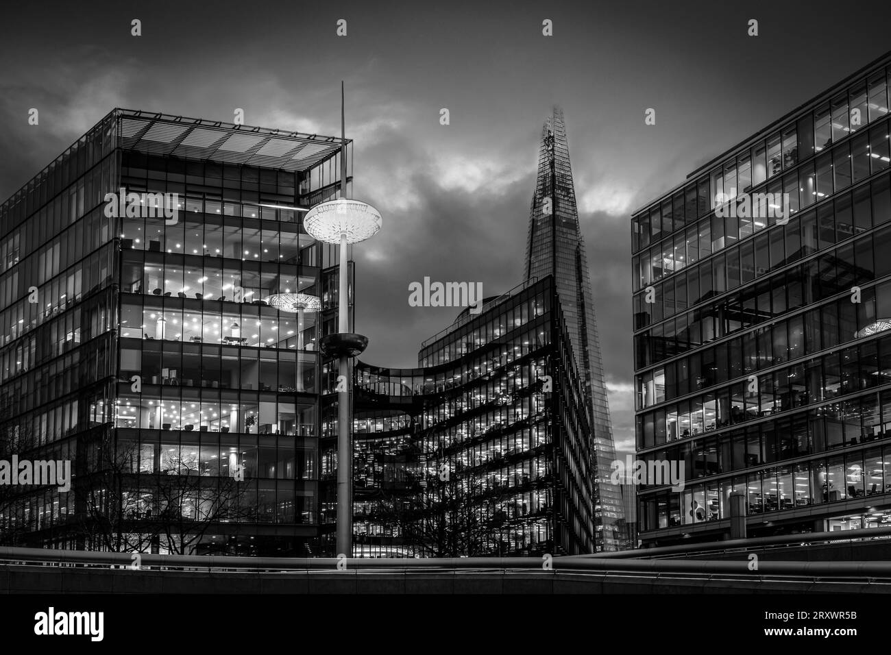 Metropolis - Stadtbild von London zur blauen Stunde - Wolkenkratzer mit Bürobeleuchtung an und Gebäude und Lichtreflexe in der Themse Stockfoto
