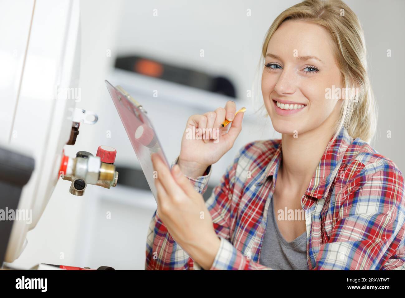 Weibliche Klempner Arbeiten an zentralen Heizkessel Stockfoto