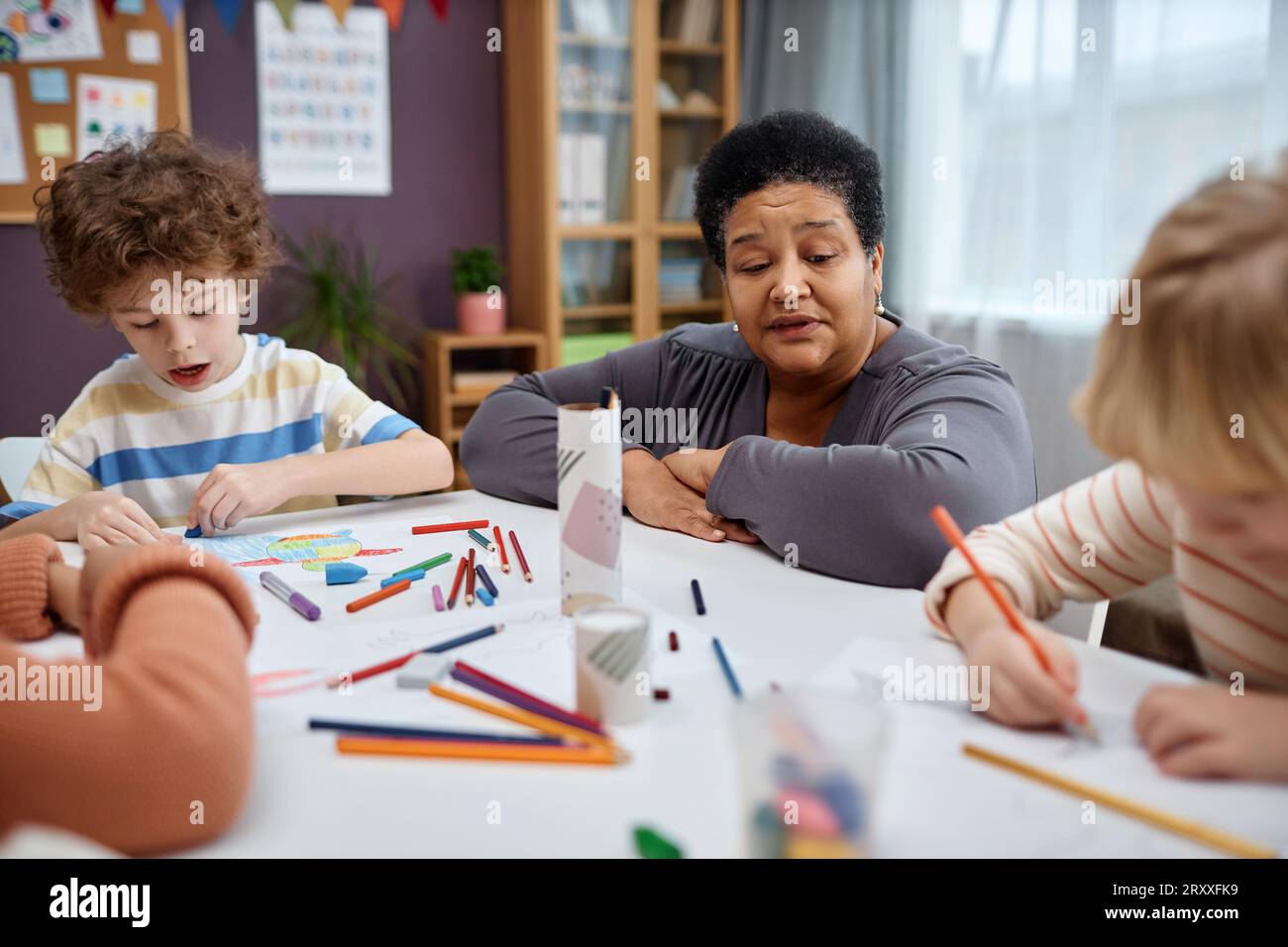 Porträt einer Reifen Schwarzen Frau als Lehrerin, die mit Kindern in der Kunst- und Handwerksklasse im Vorschulalter arbeitet Stockfoto