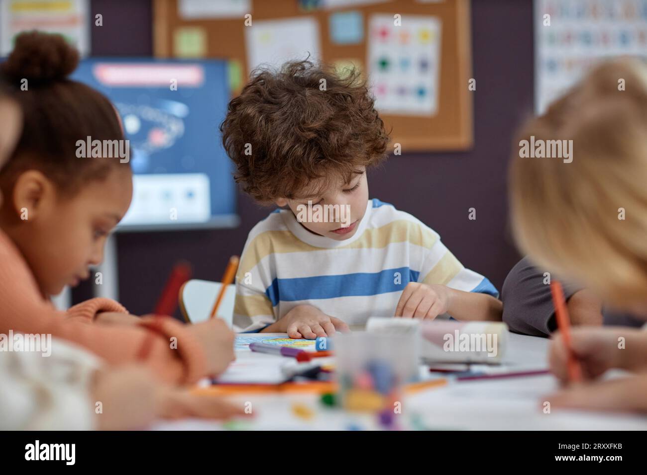 Porträt von süßen Jungen Malbilder am Tisch mit einer Gruppe von Kindern in Kunst- und Bastelunterricht im Vorschulalter, Kopierraum Stockfoto