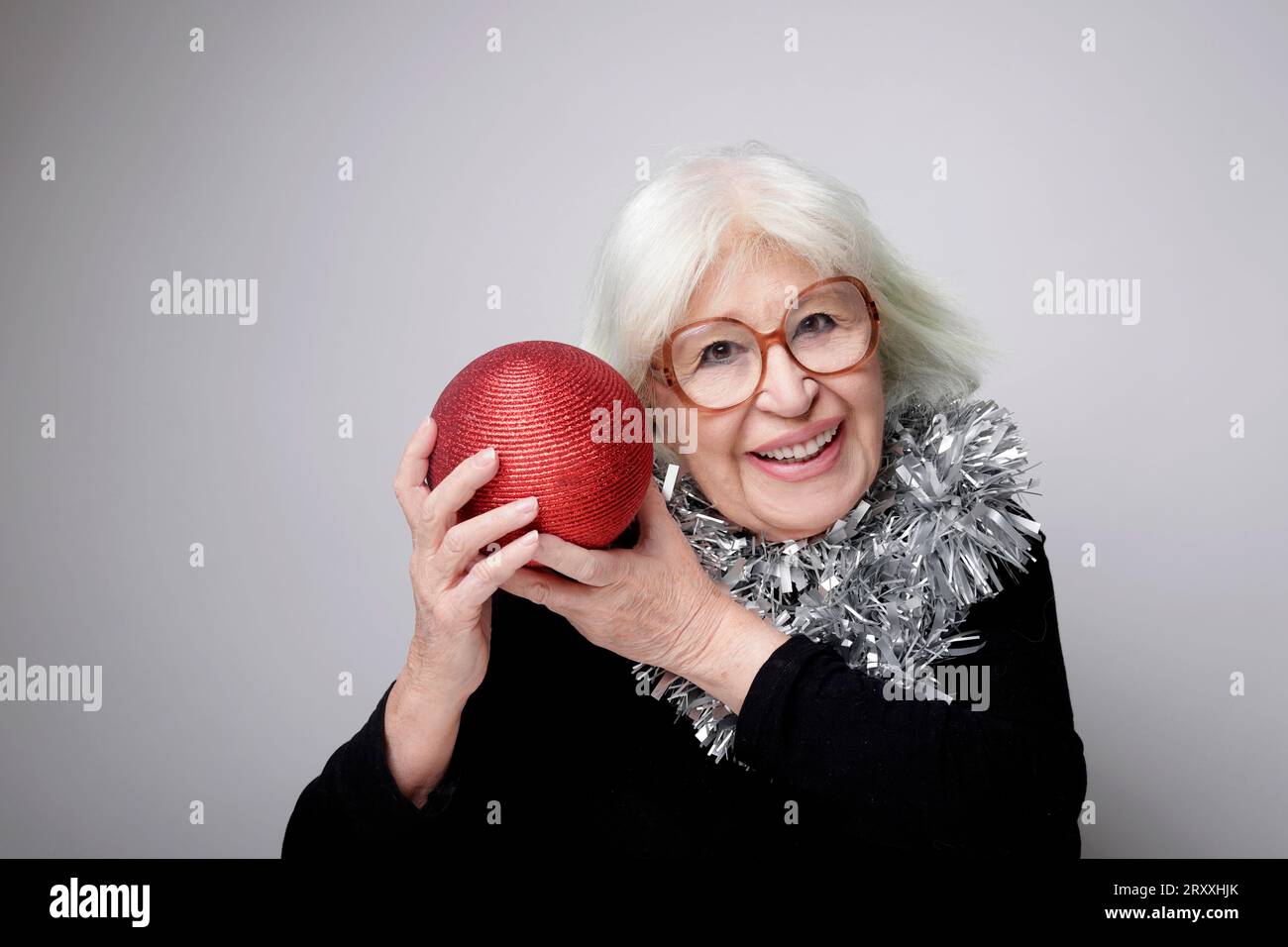 Ältere Frau mit grauem Haar und Weihnachtsschmuck Stockfoto