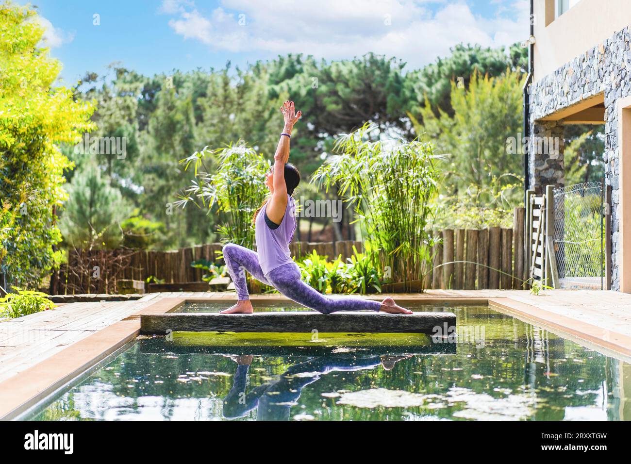 Eine Frau, die die Yoga-Pose praktiziert Crescent Lunge auf dem Knie (Anjaneyasana) Stockfoto