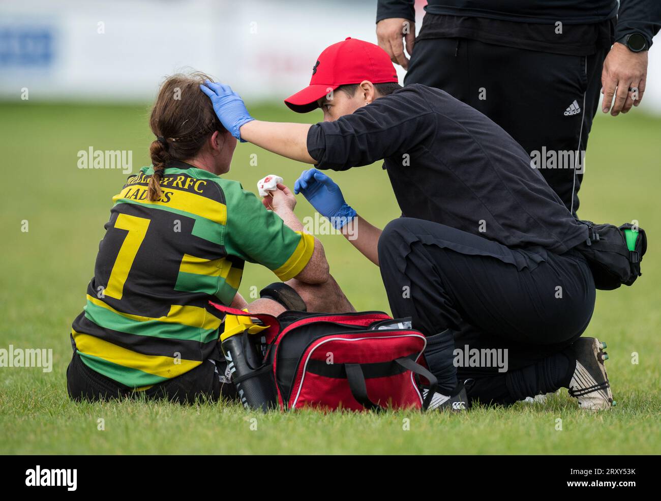 Die englische Amateurspielerin der Rugby Union erhält erste Hilfe während eines Ligaspiels. Stockfoto