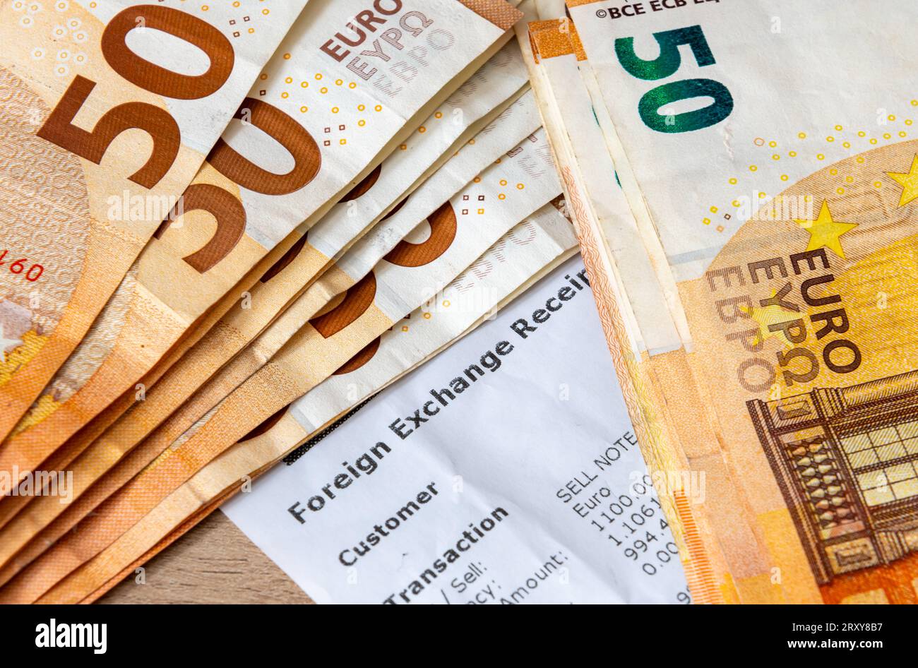 Eine Devisenquittung mit fünfzig Euro-Banknoten oben. Urlaub, Reisegeld, Geldwechselkonzept. Stockfoto