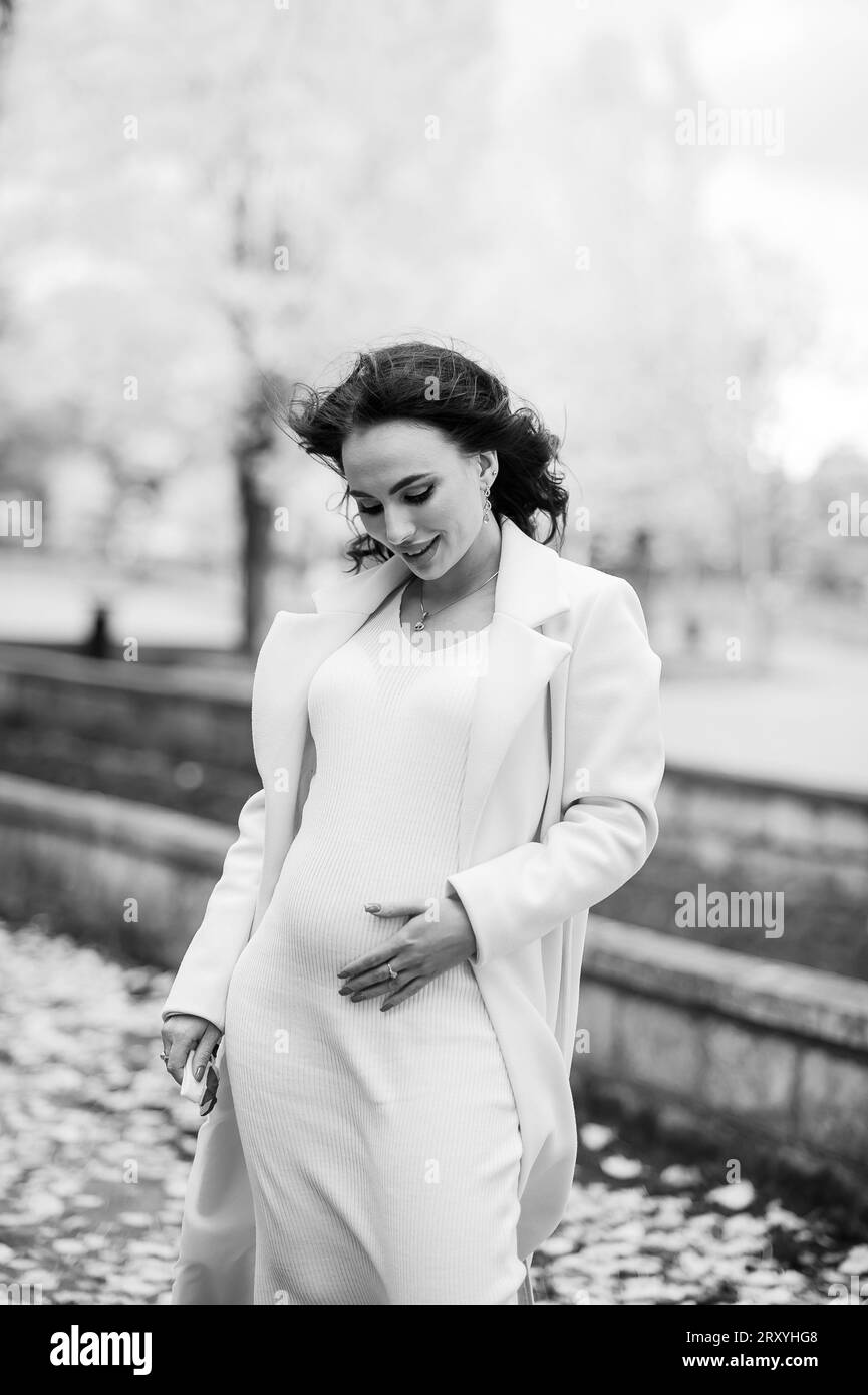 Schwangere Frau im Mantel in einem Herbstpark Stockfoto